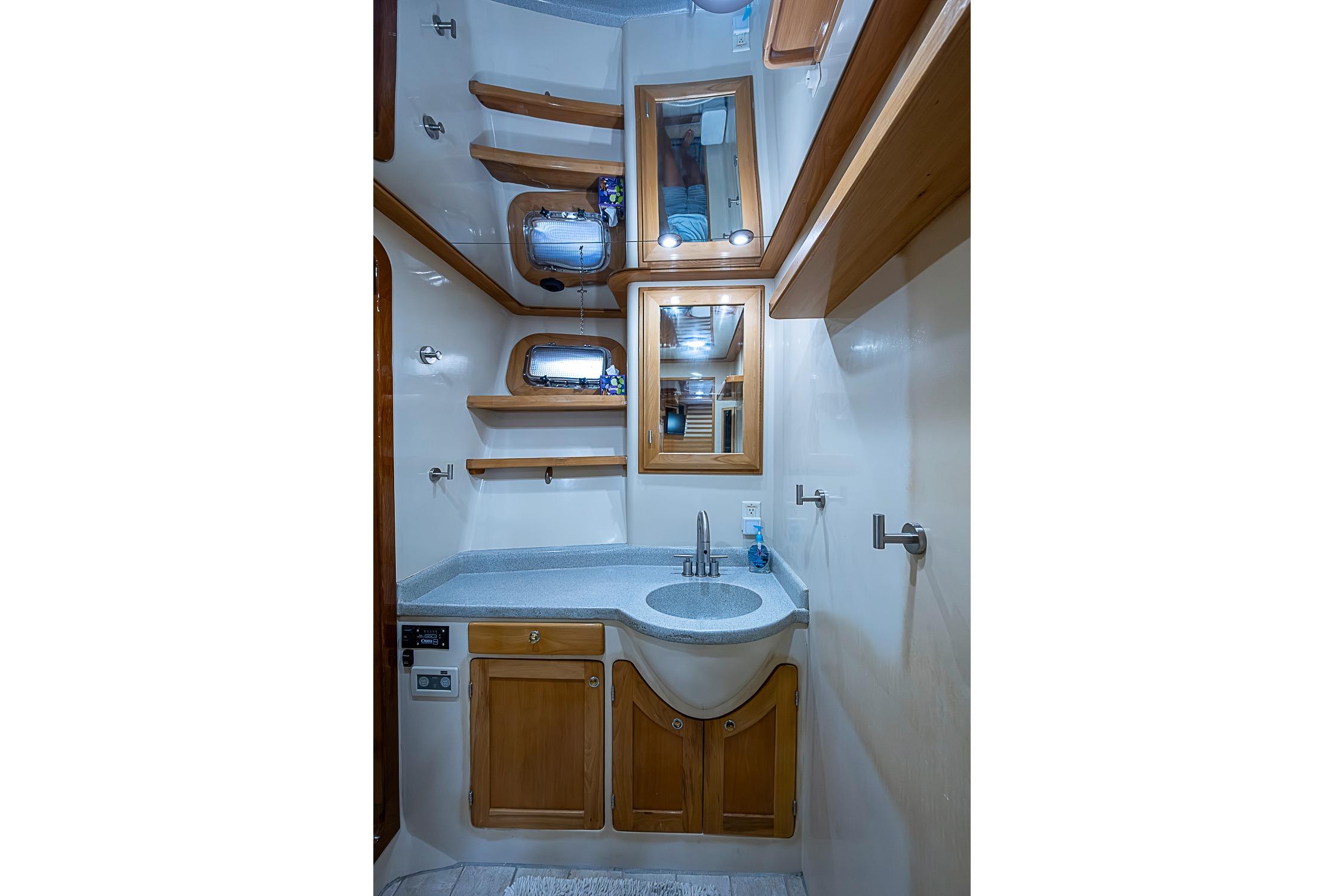 Luxurious bathroom in 2003 Magna Marine Nova Scotia 47 yacht, featuring wooden cabinetry and modern fixtures.