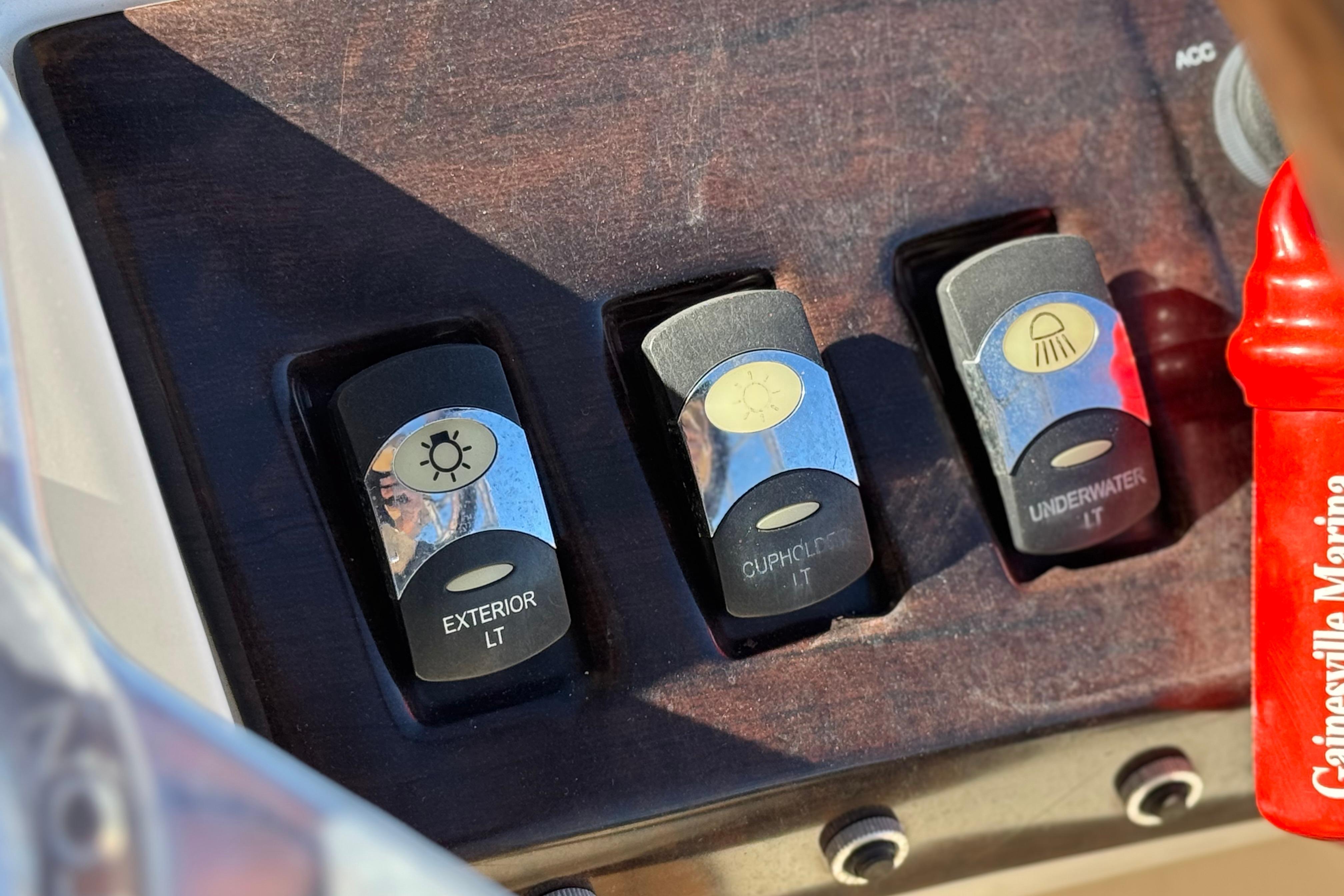 2013 Bennington 2575QCW I/O boat dashboard with light switches for exterior, cupholder, and underwater.