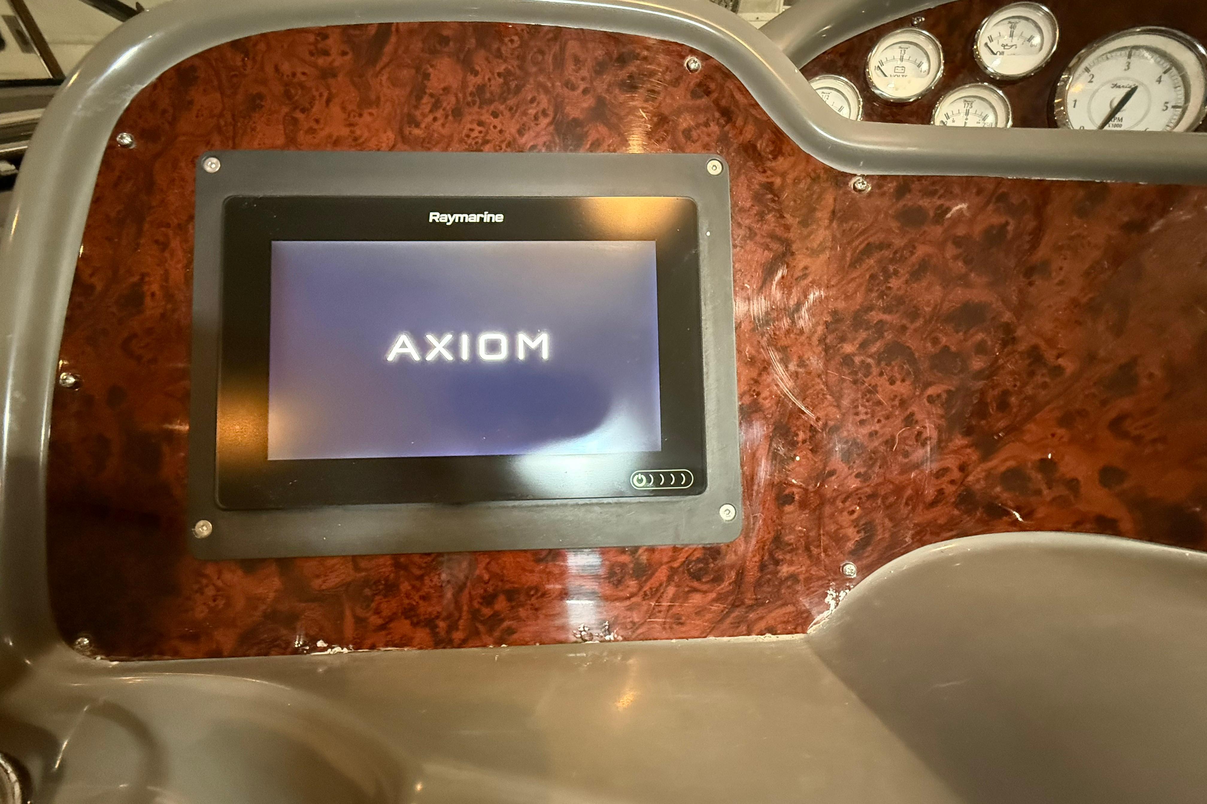 2007 Regal Commodore 3760 IO dashboard with Raymarine Axiom display and gauges.