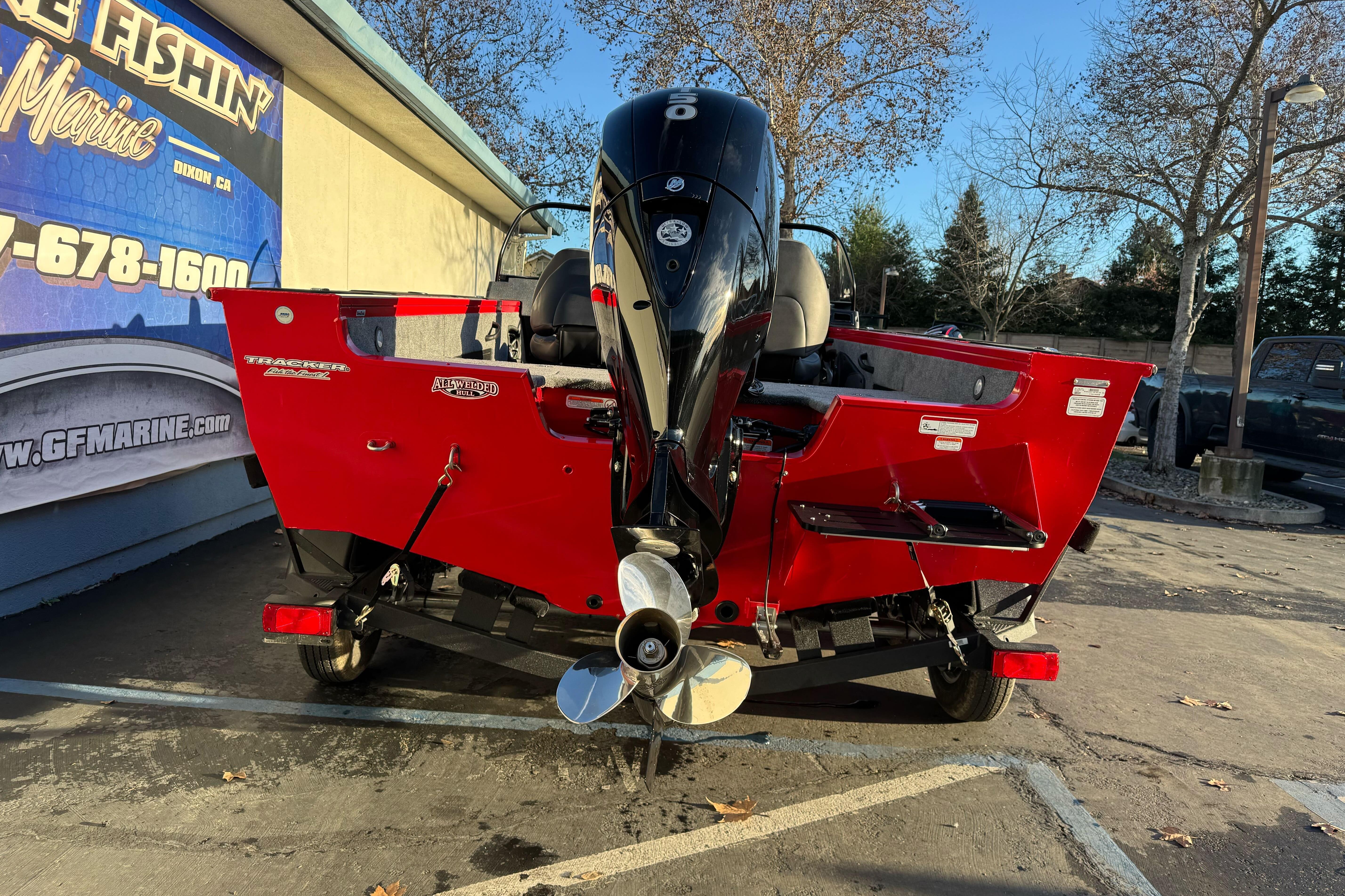 2026 Tracker Targa V-18 WT boat, red exterior, parked outdoors with outboard motor.