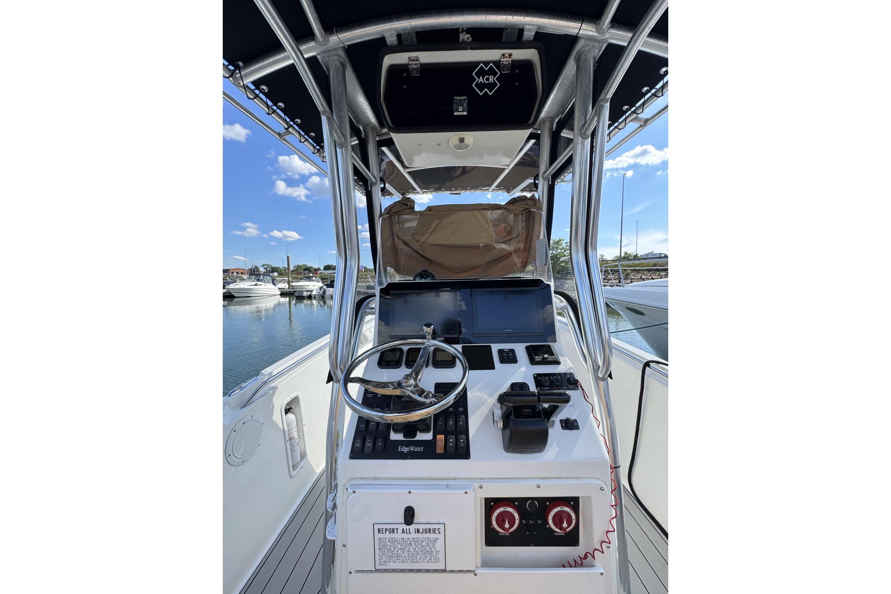 2007 Edgewater 245CC boat console with steering wheel, controls, and navigation screens.