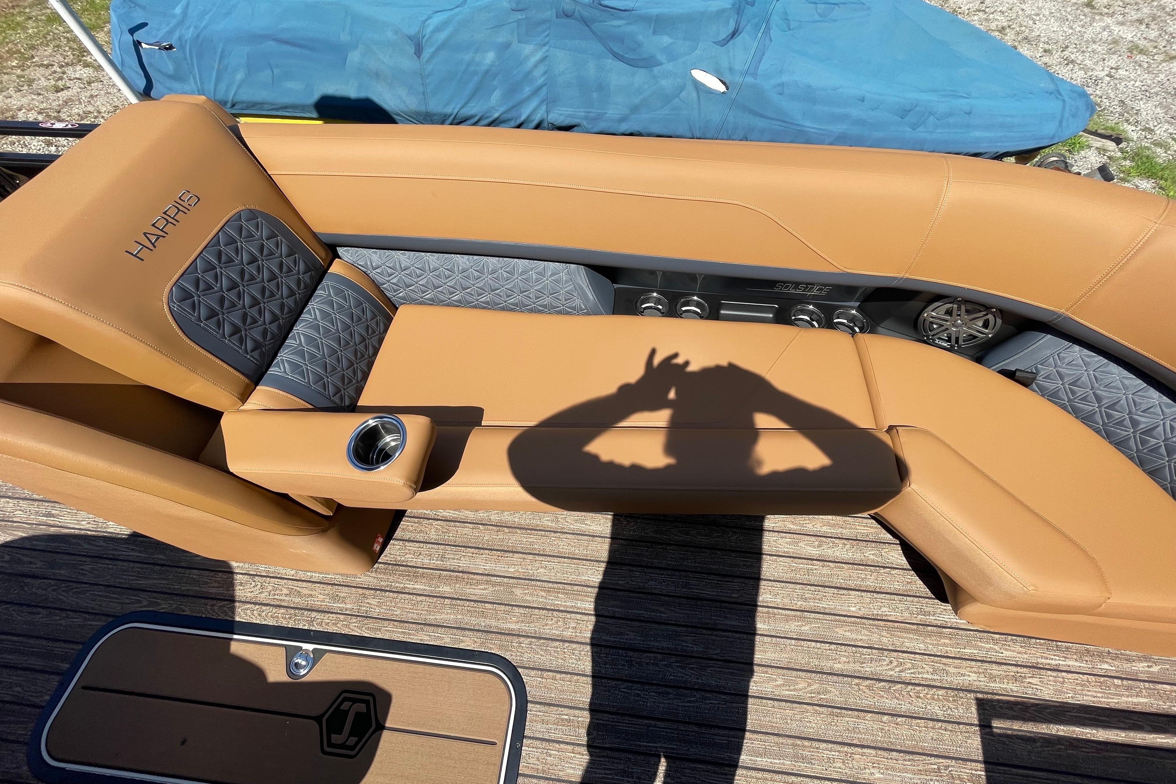 Luxury seating on 2026 Harris Solstice 250 SLDH boat with tan upholstery and cup holder.