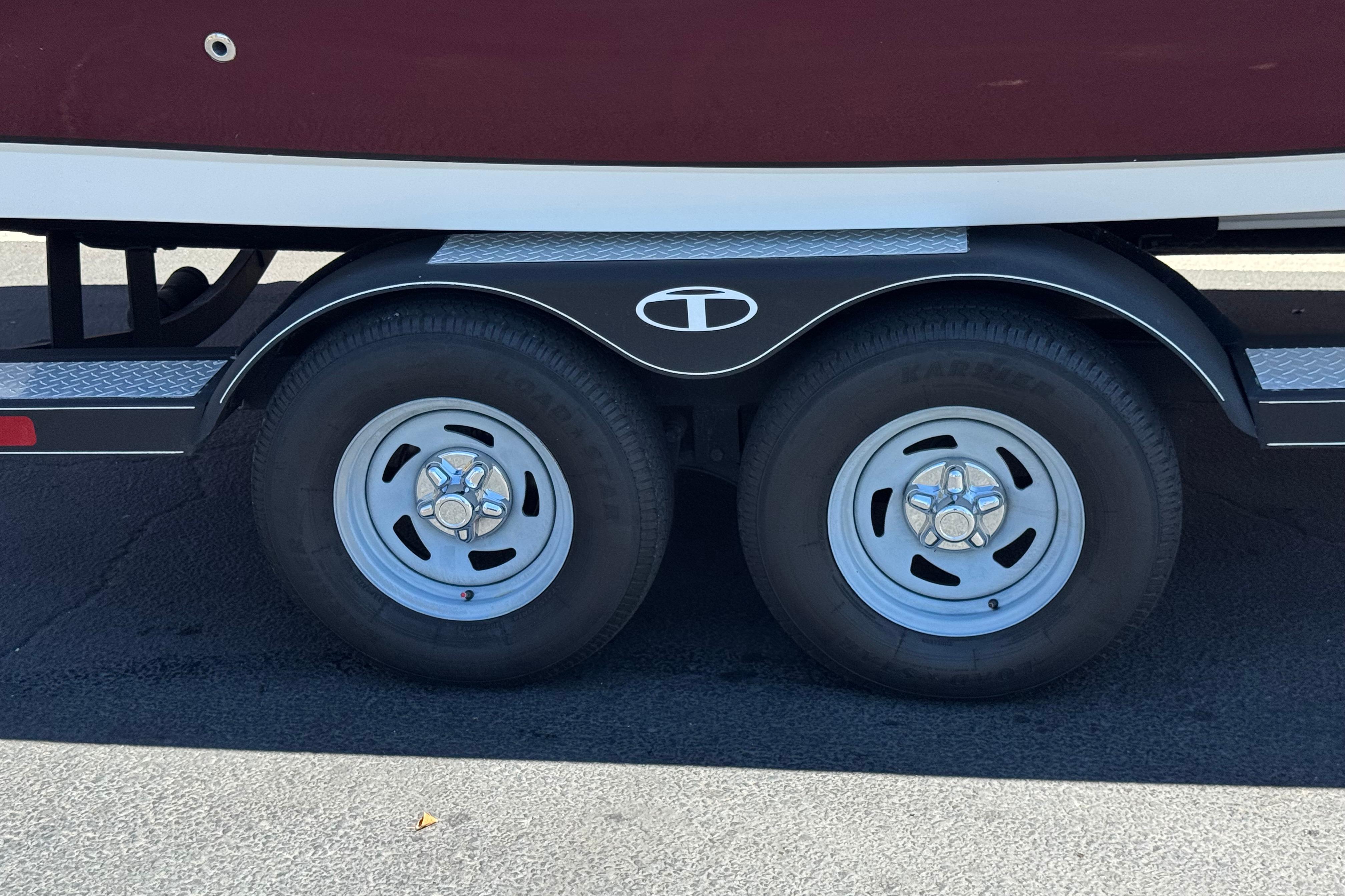 Trailer wheels of a 2017 Tahoe 2150 boat on a sunny day.