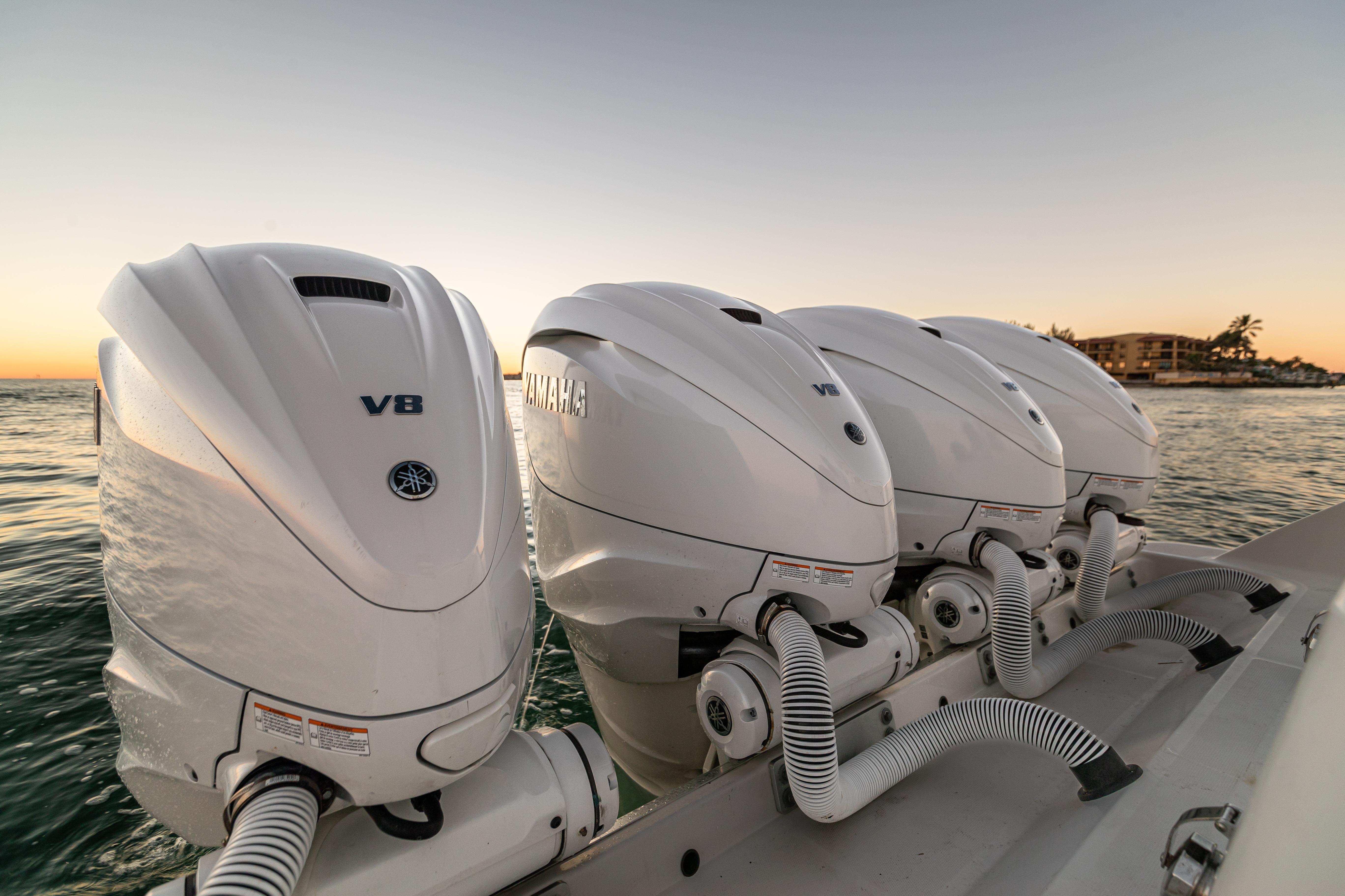 Four Yamaha V8 outboard engines on a 2018 HCB 53 Suenos RXV at sunset.