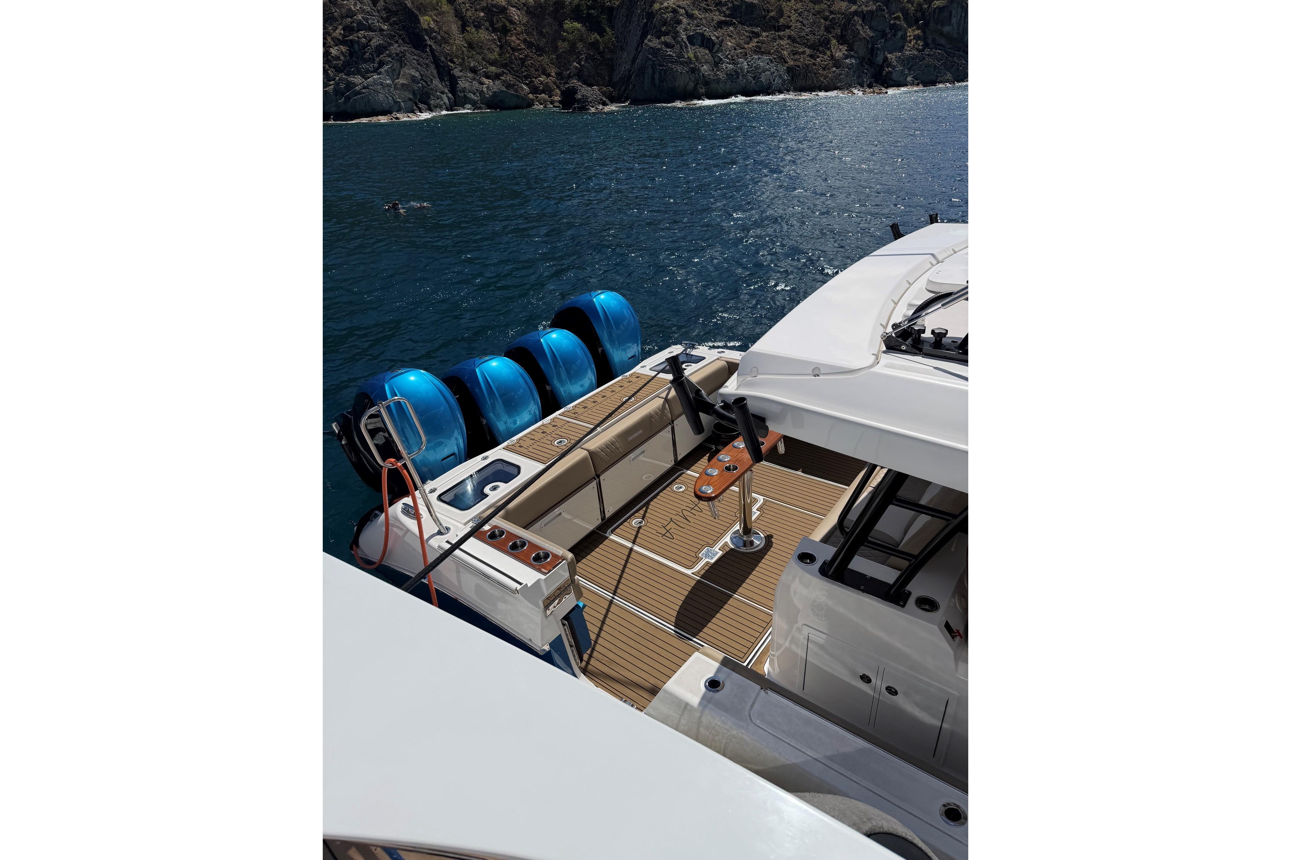 2022 Everglades 455 Center Console boat with four blue outboard motors on a scenic waterway.