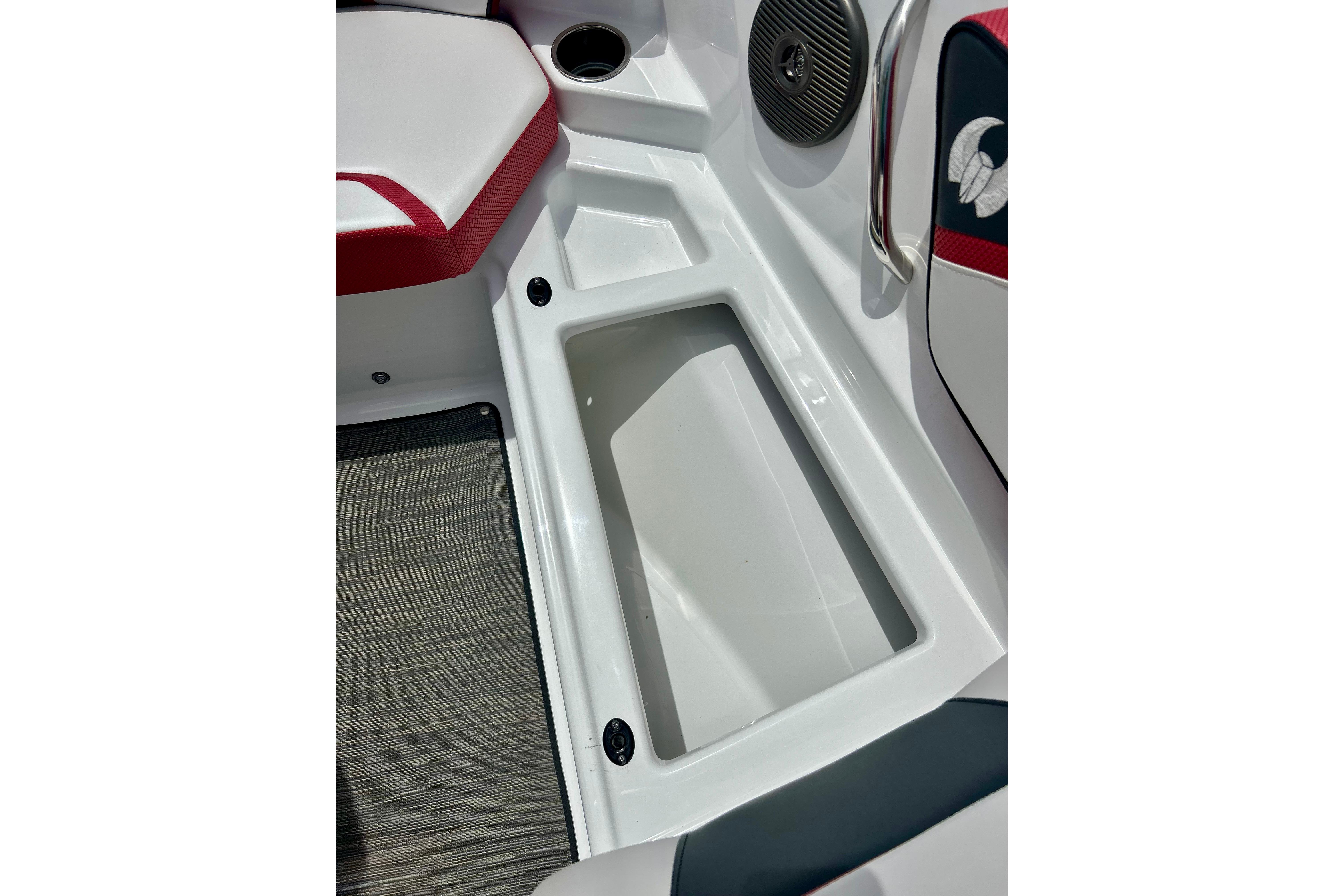 Interior of 2021 Scarab 195 ID boat featuring storage compartment and seating area.