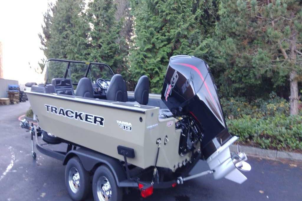 2026 Tracker Targa V-19 Combo boat on trailer, parked near trees.