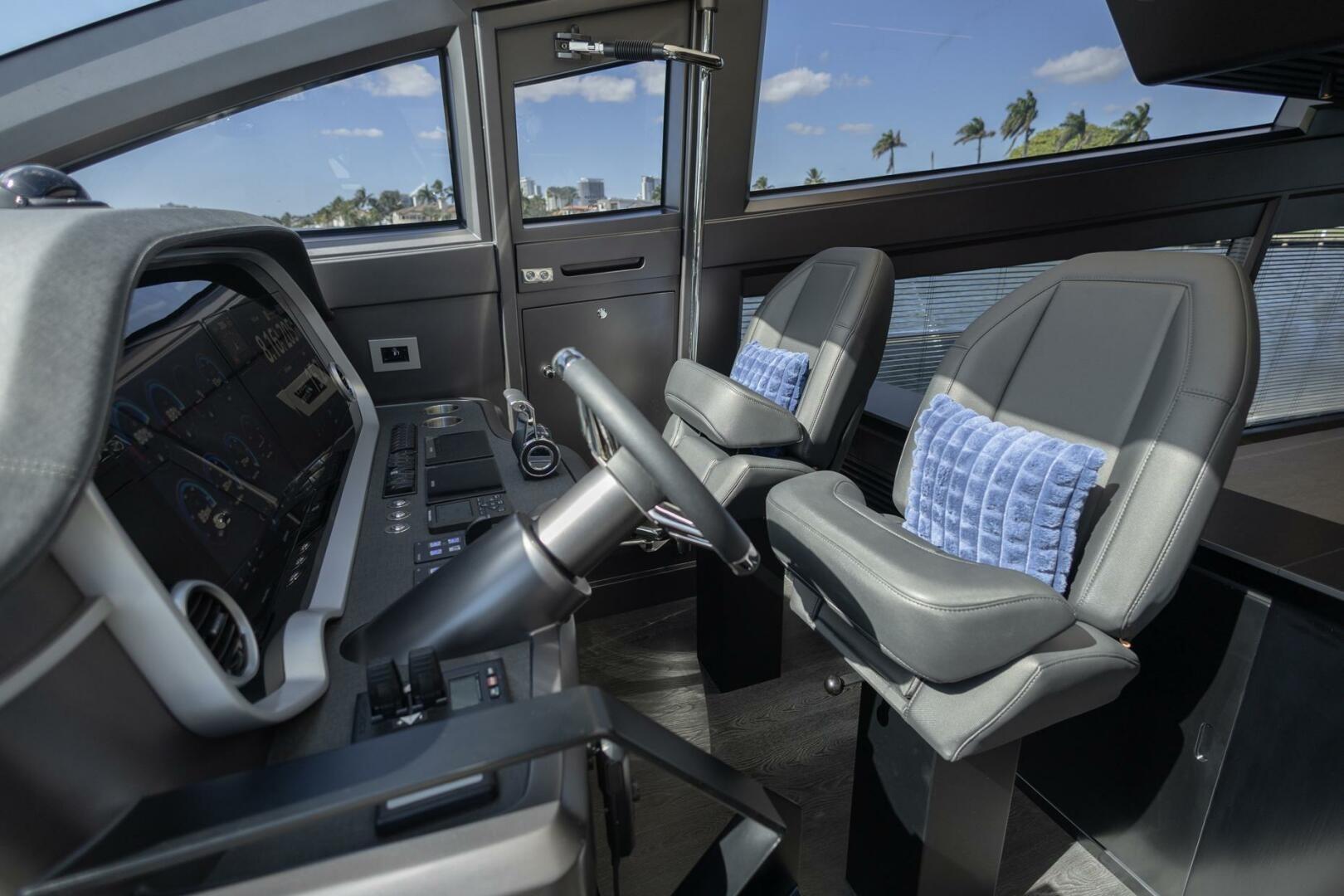 Interior of 2023 Pearl 72 yacht cockpit with modern controls and plush seating.