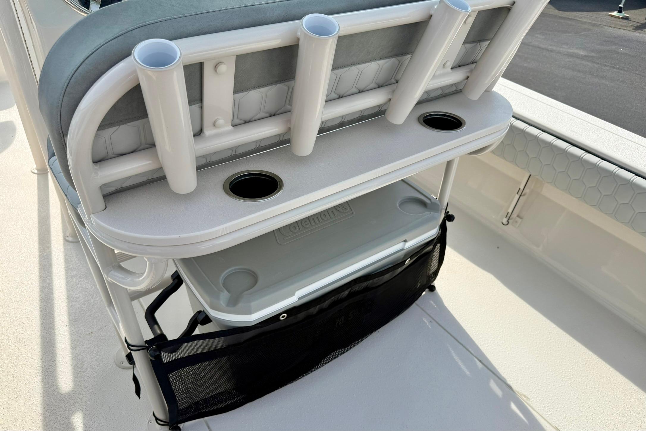 2026 Carolina Skiff 24 Ultra Elite boat seating with rod holders and storage compartment.