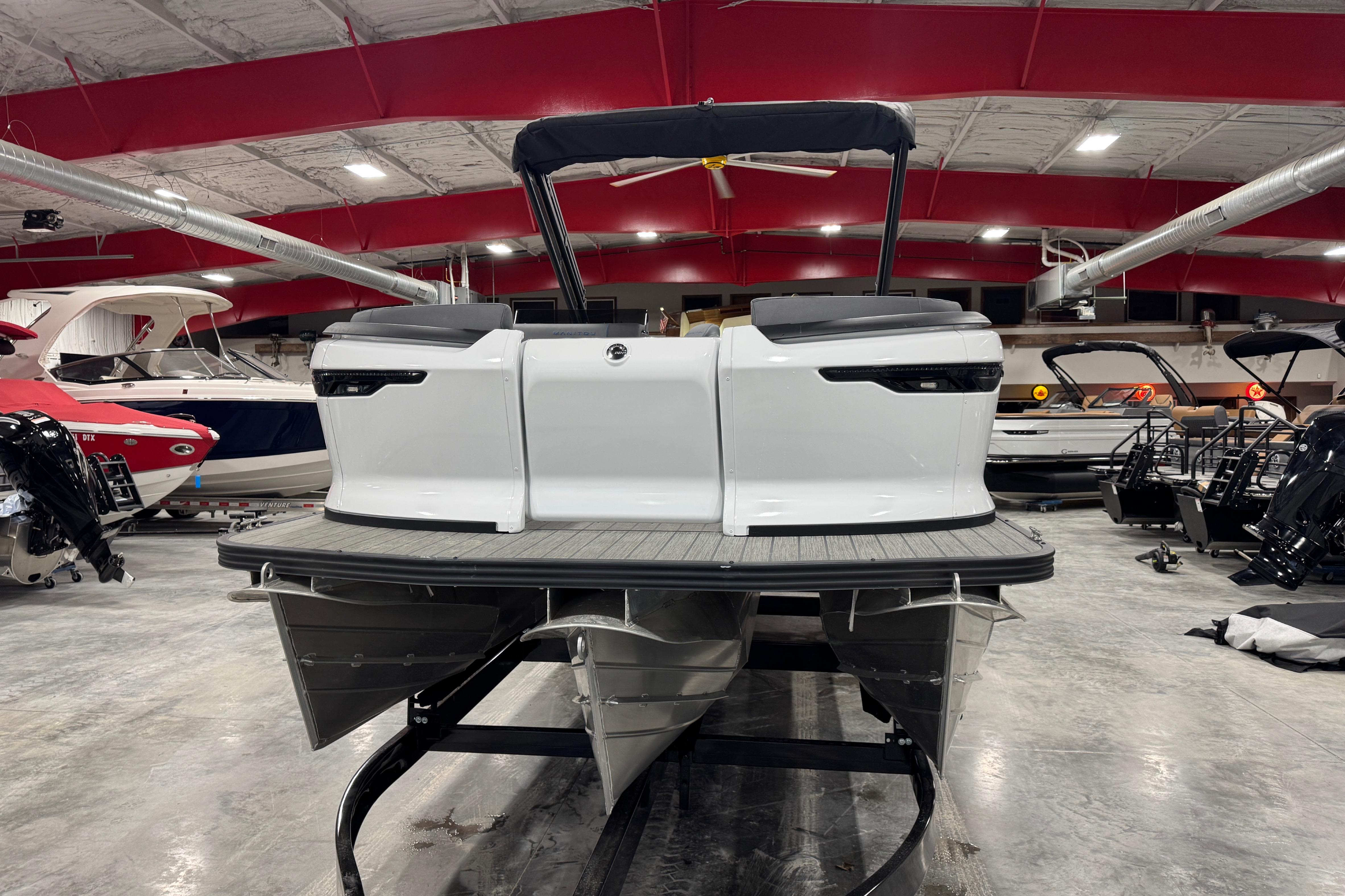 2025 Manitou 24 Explorer pontoon boat in showroom, rear view.