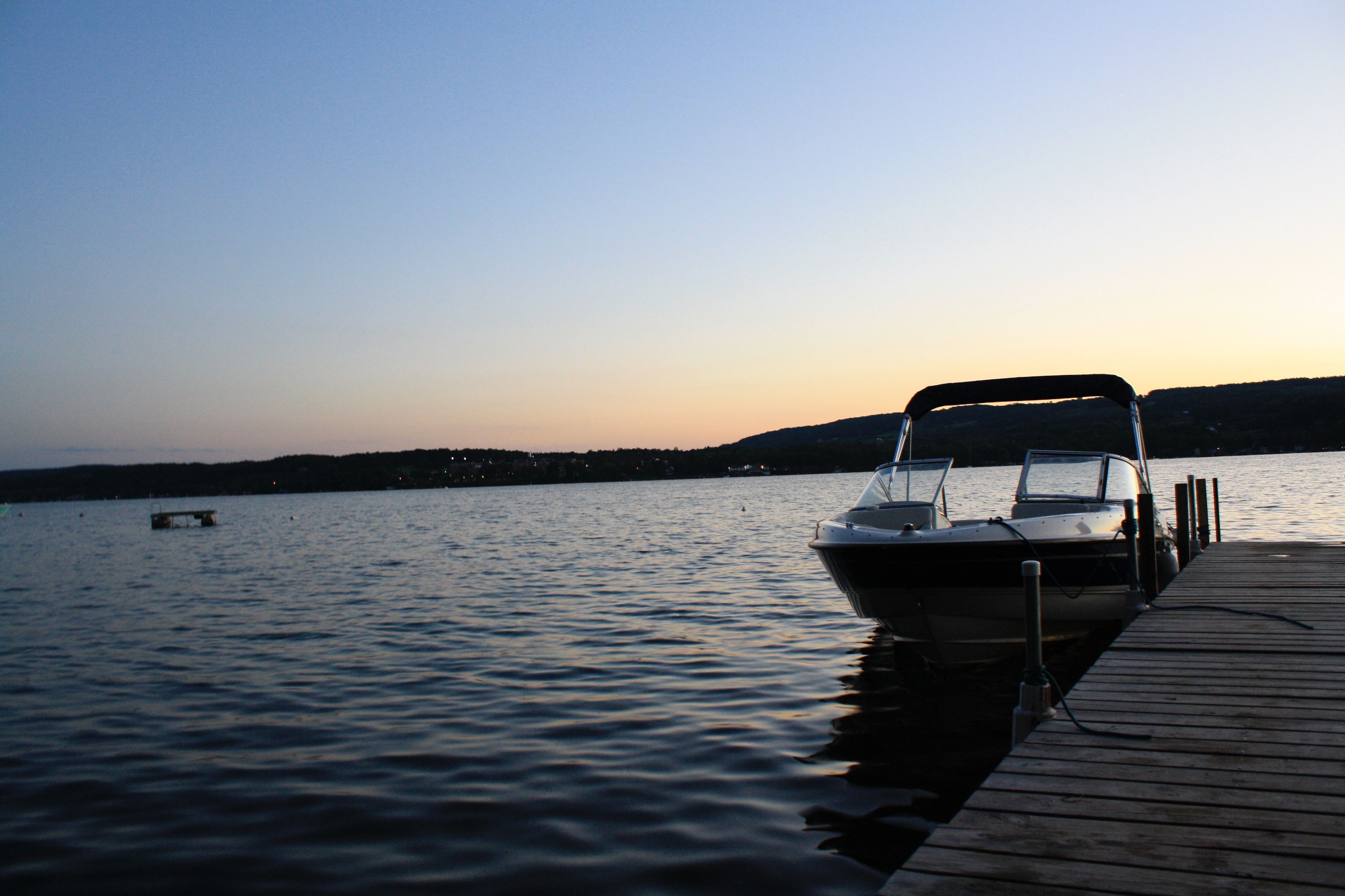 2005 Bayliner 205BR docked at sunset on a calm lake.