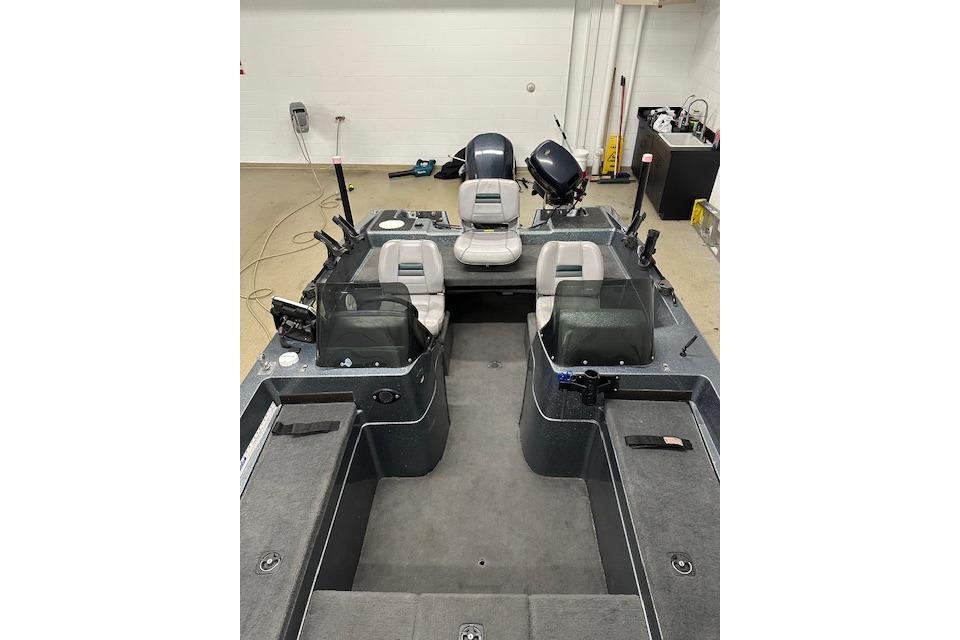1999 Stratos 219 CF boat interior with seating and controls in a garage setting.