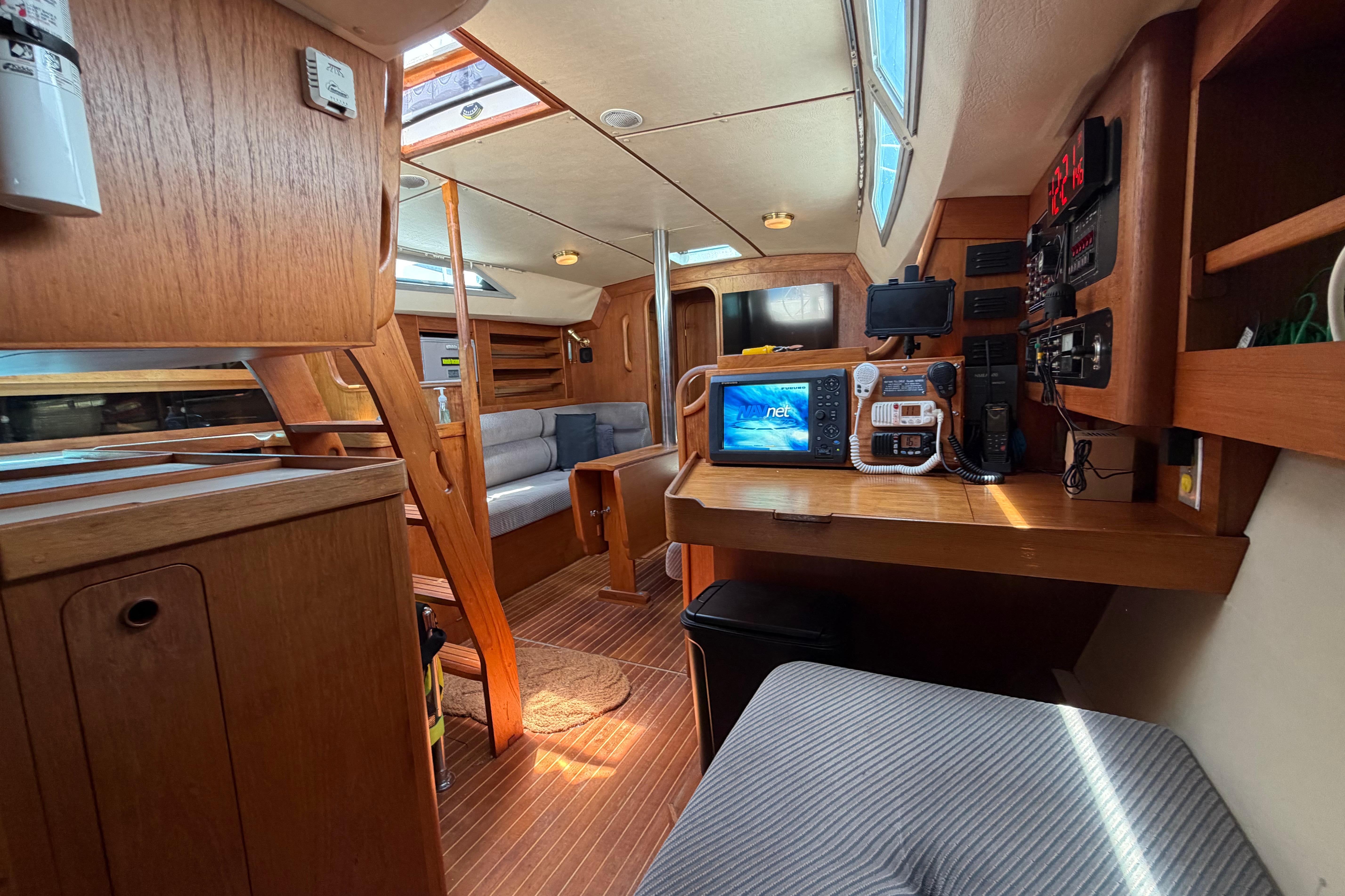 Interior of a 1987 Moody 376 sailboat with wooden furnishings and navigation equipment.