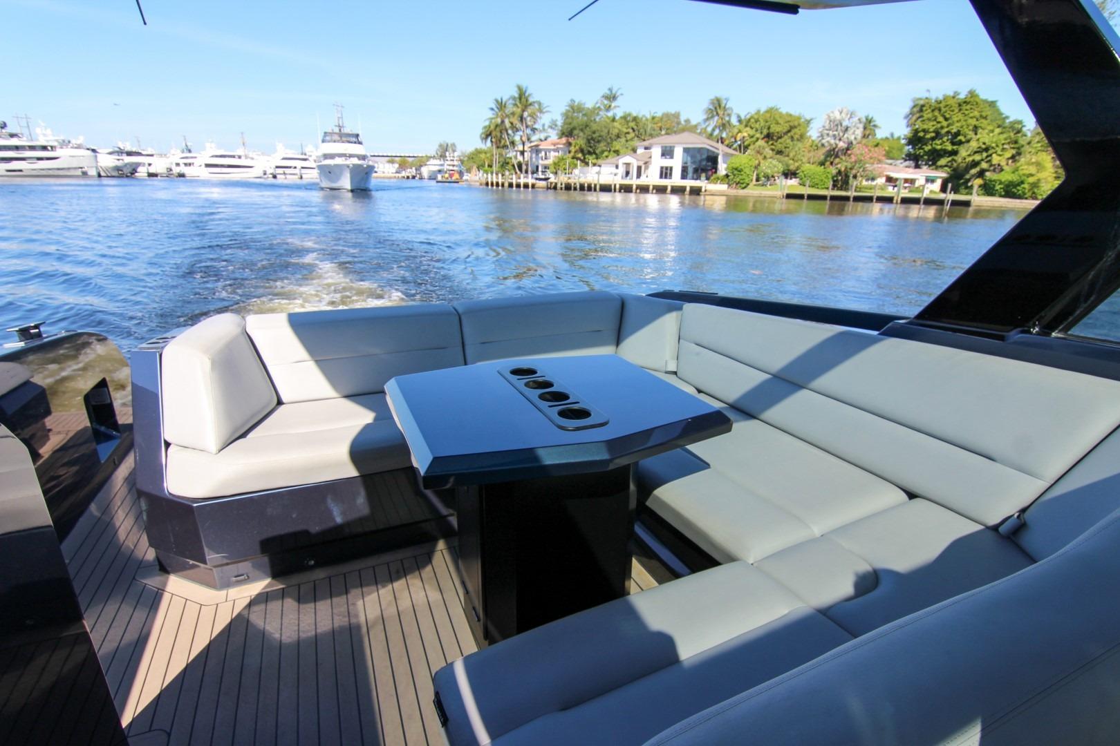 Luxurious seating area on 2022 Vanquish Yachts VQ45, cruising on a scenic waterway.