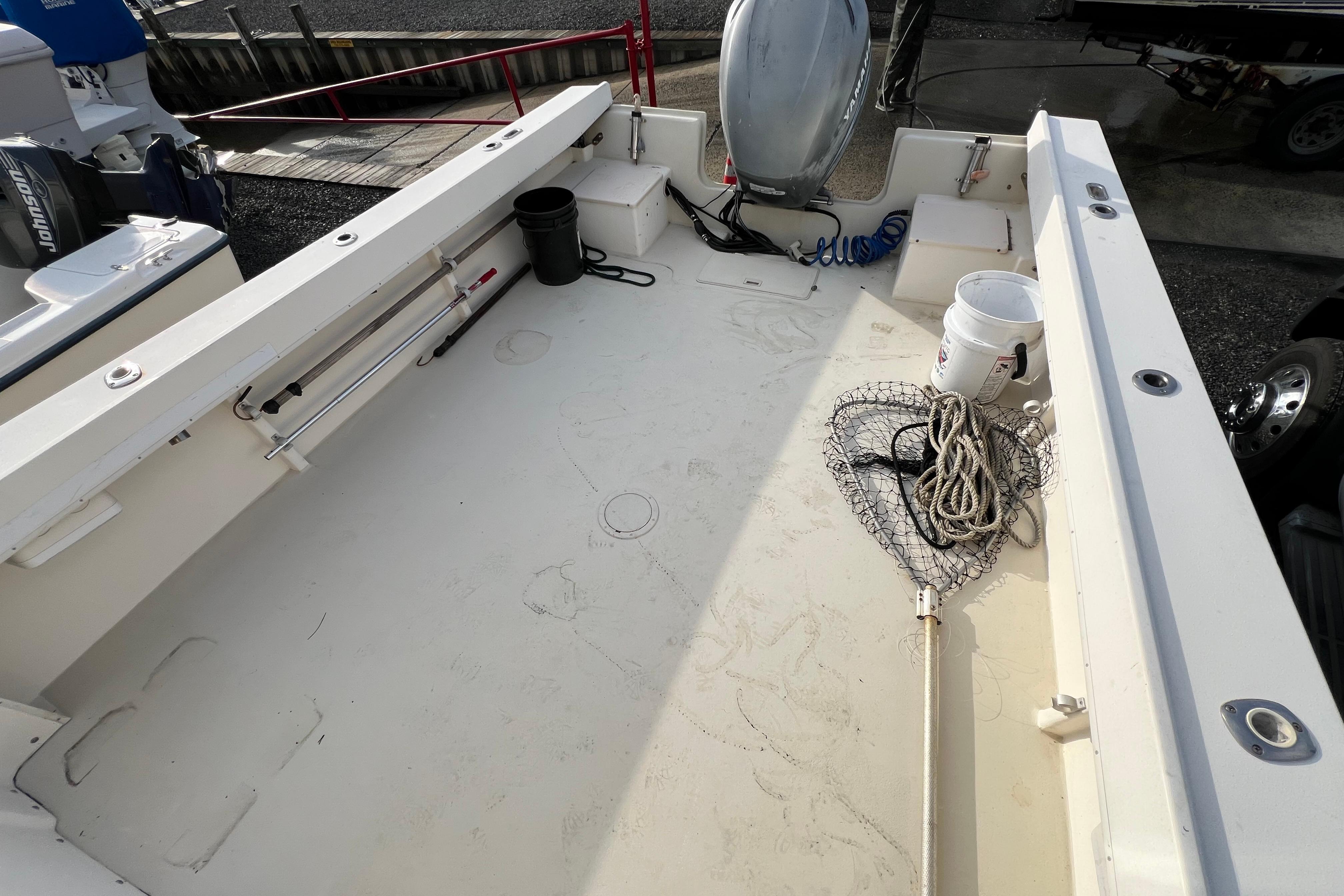 2001 Parker 2520 Deep Vee Sport Cabin boat deck with fishing gear and equipment.