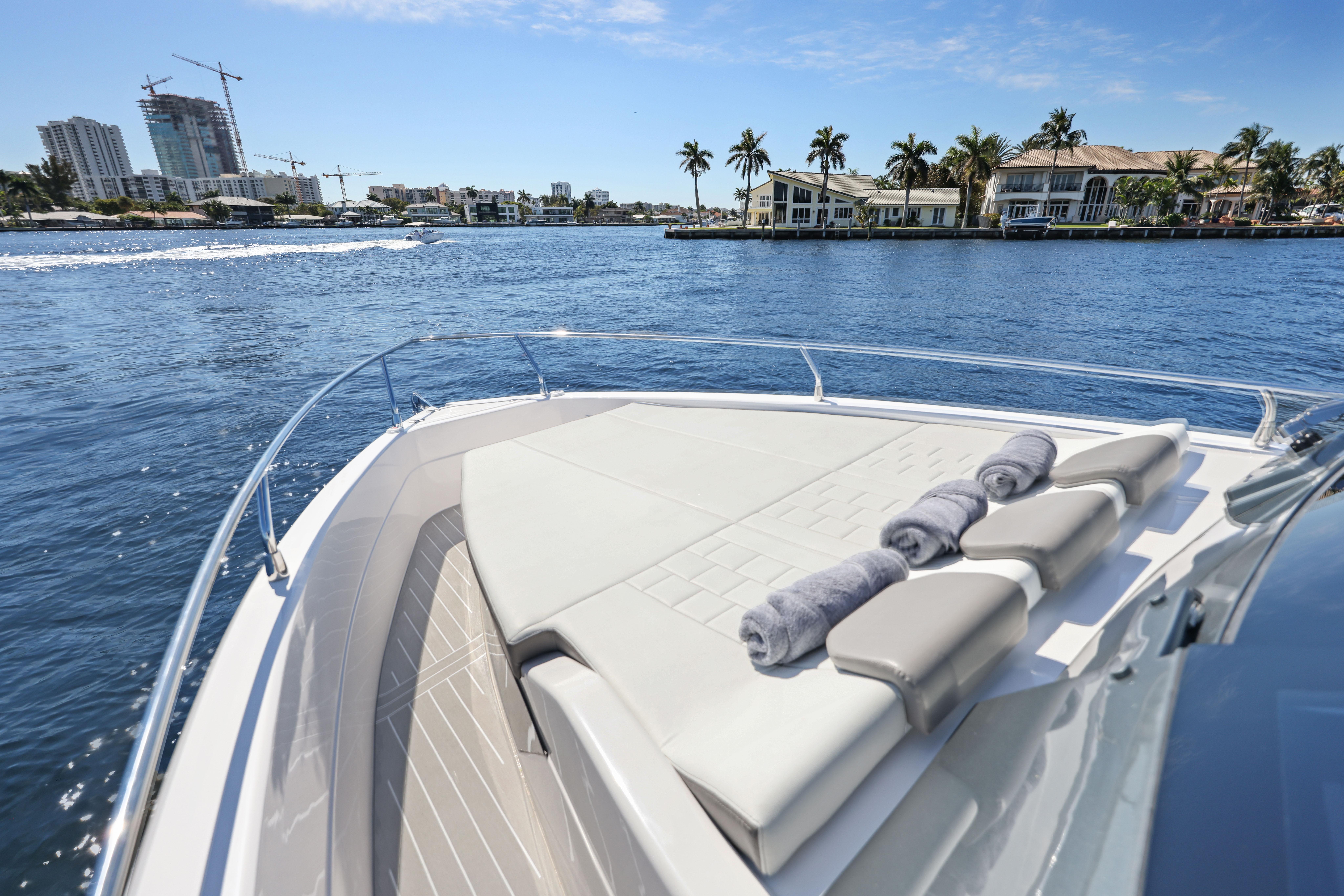 2025 Valiatt 380 Bowrider cruising on a sunny waterfront with luxury homes.