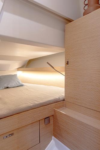 Interior cabin of 2025 Hanse 360 yacht, featuring a cozy bed and modern design.