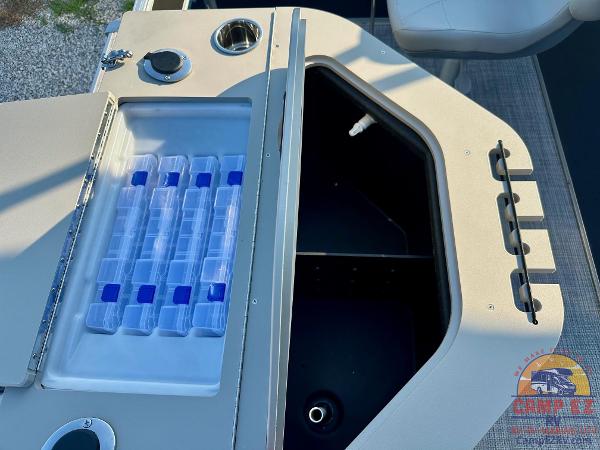 2025 South Bay 224FCR LE boat storage compartment with tackle boxes and cup holder.