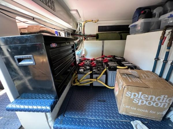 Interior of a 2009 Ovation 52 with tool chest, batteries, and storage box.