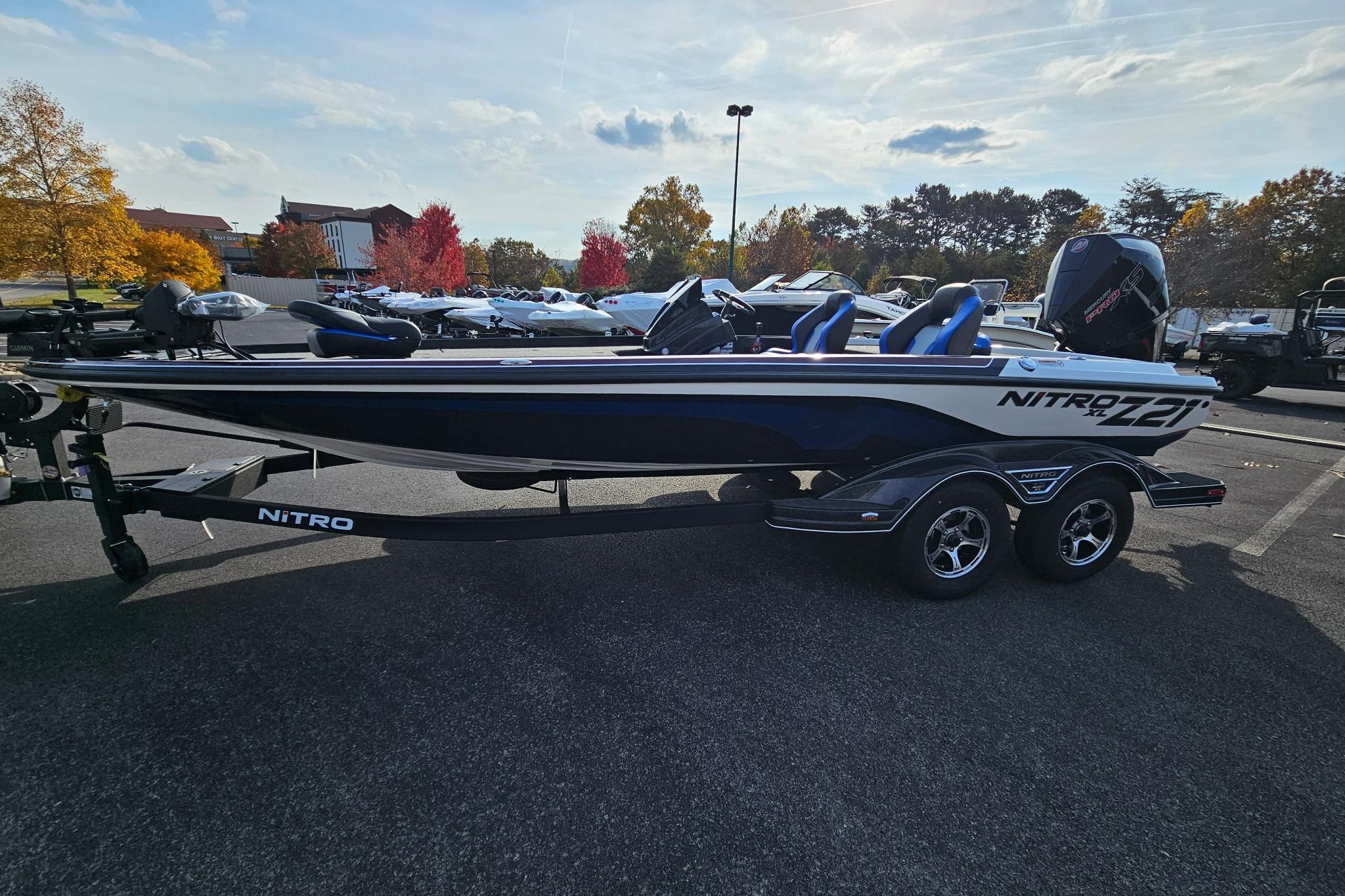 2026 Nitro Z21 XL Pro boat on trailer in parking lot, surrounded by autumn trees.