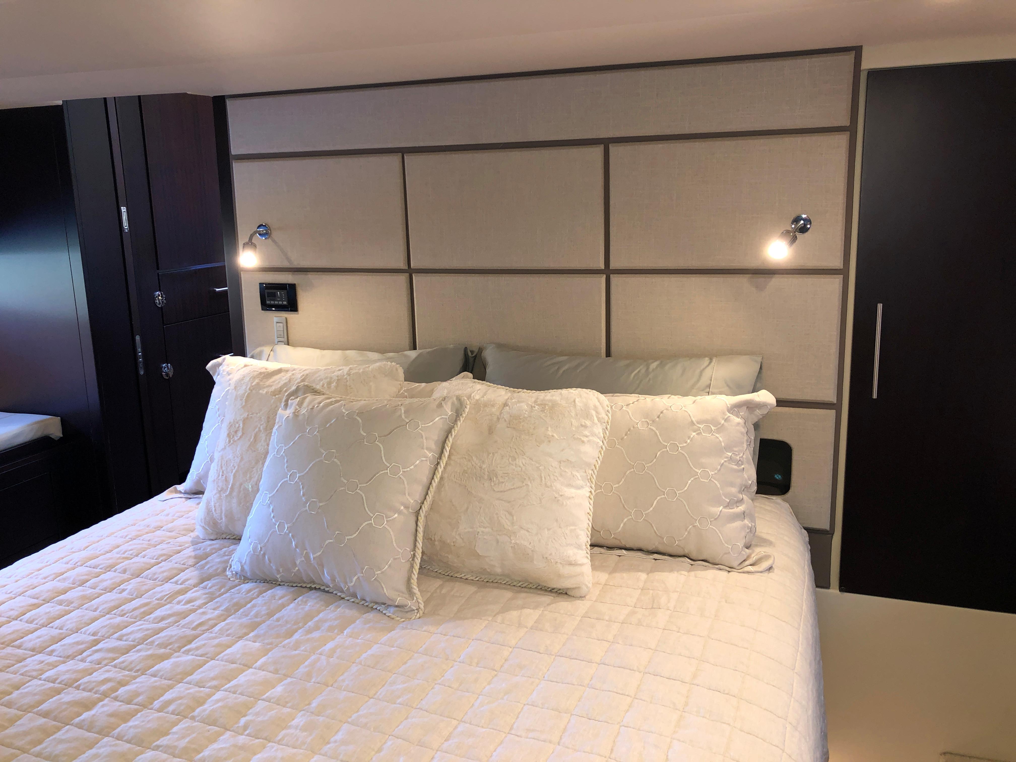 Luxurious bedroom interior of 2017 Regal 53 Sport Coupe yacht with elegant bedding.