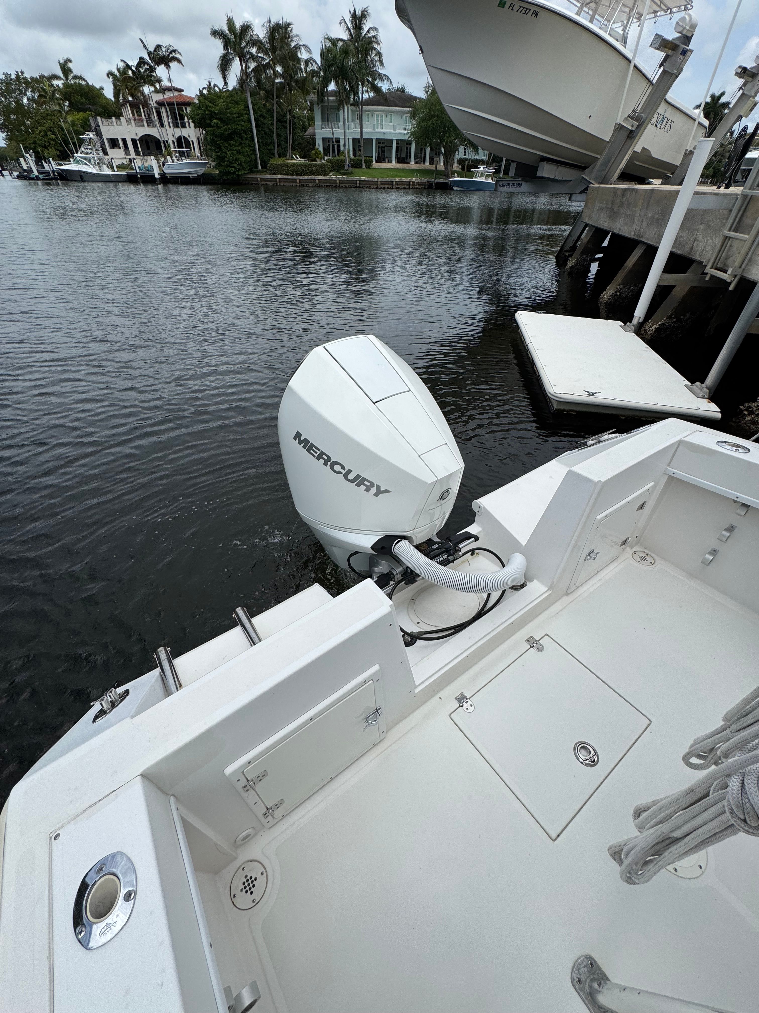 A 2004 Contender 21 boat with a Mercury outboard motor, docked by the water.