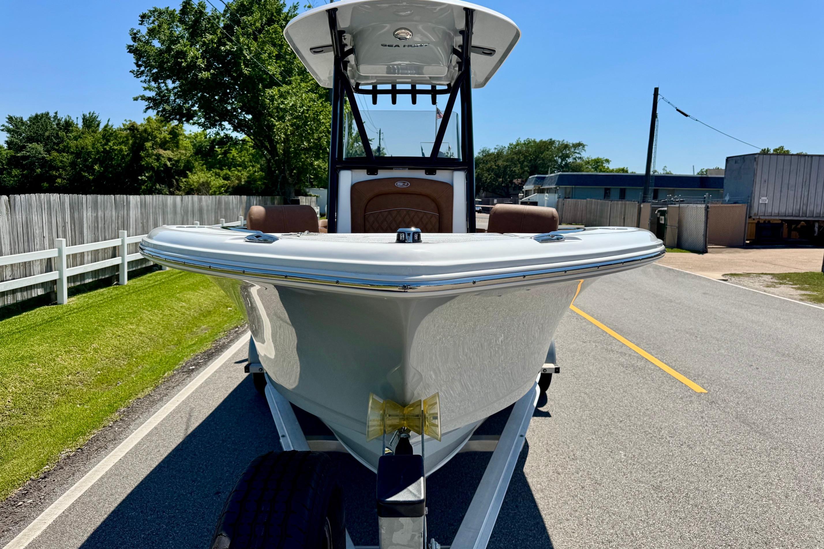 2025 Sea Hunt Ultra 219 boat on trailer, parked on a sunny street.