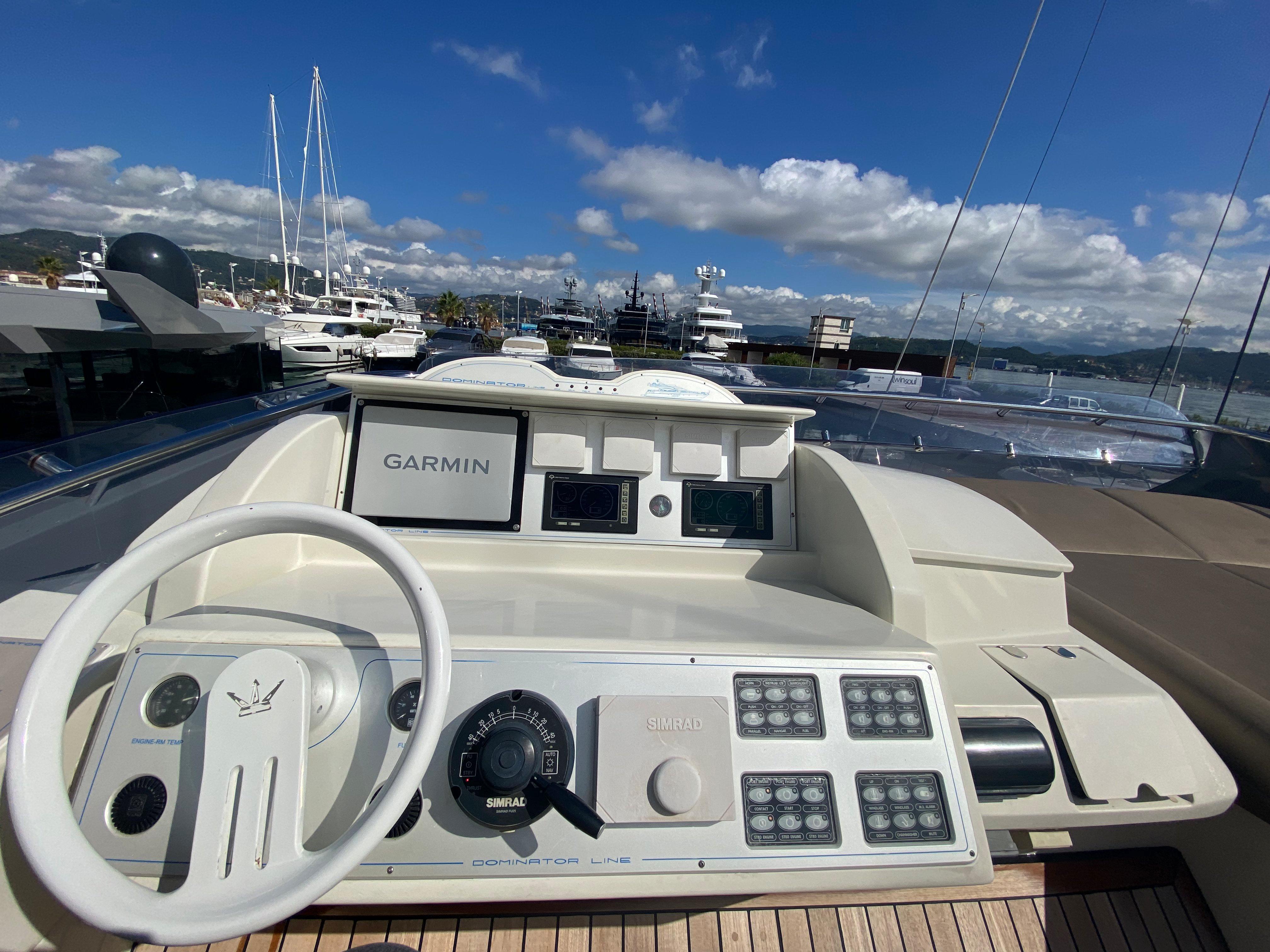 Helm of 2008 Dominator 680 yacht with Garmin navigation, docked in a marina.