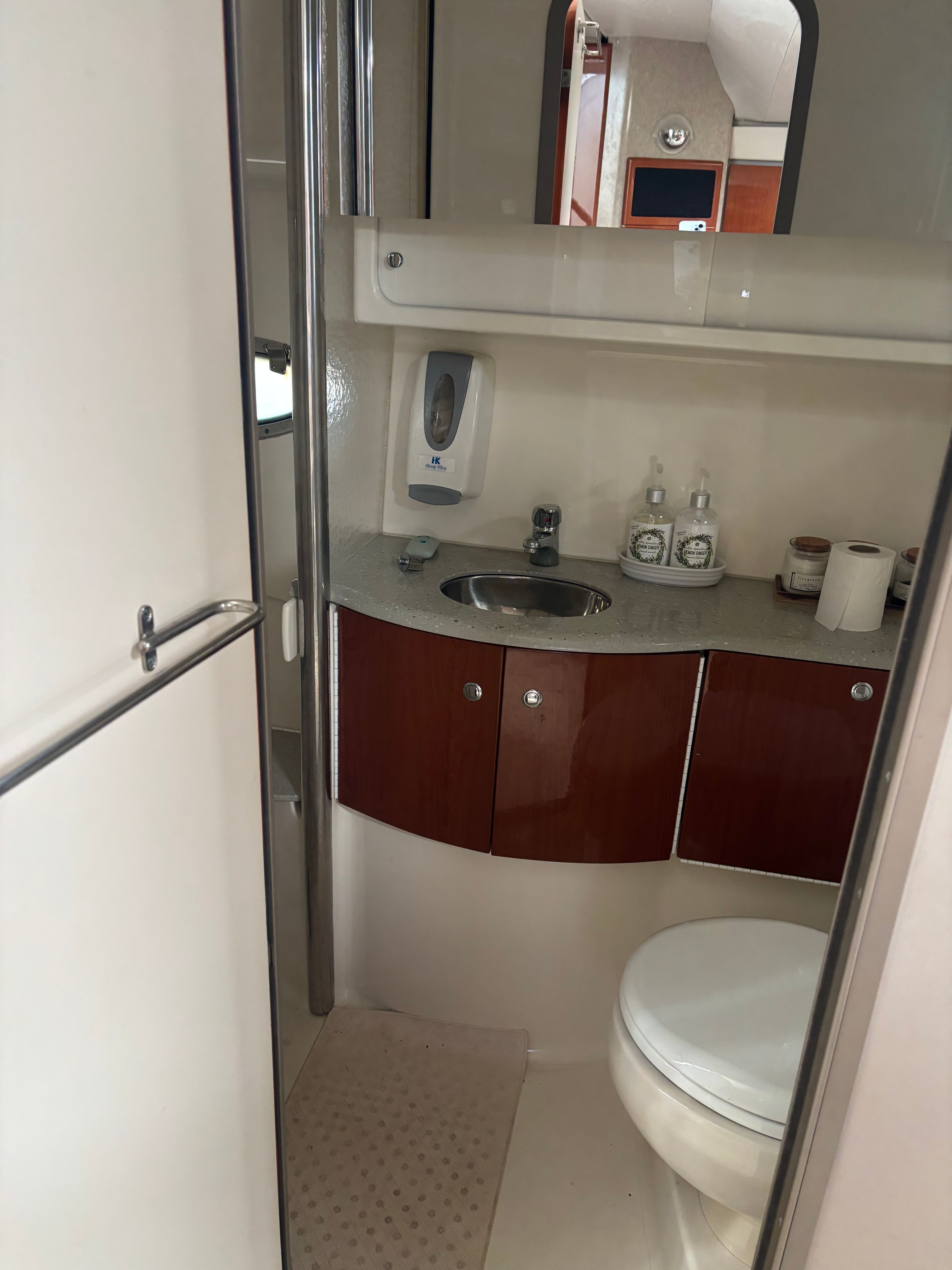 Bathroom with sink, toilet, and cabinets inside a boat.