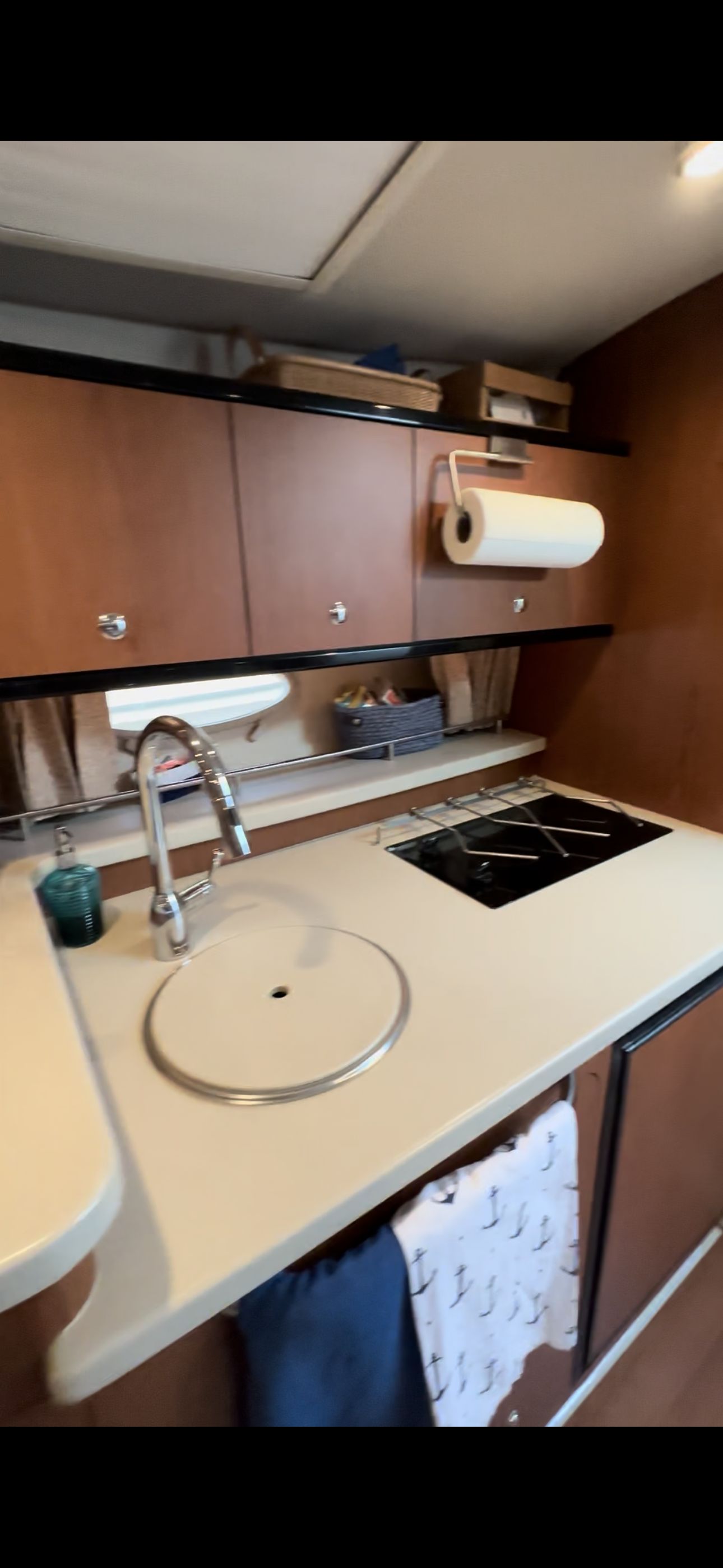 The galley of a 2004 Chaparral Signature 330 with a sink, stove, and storage.