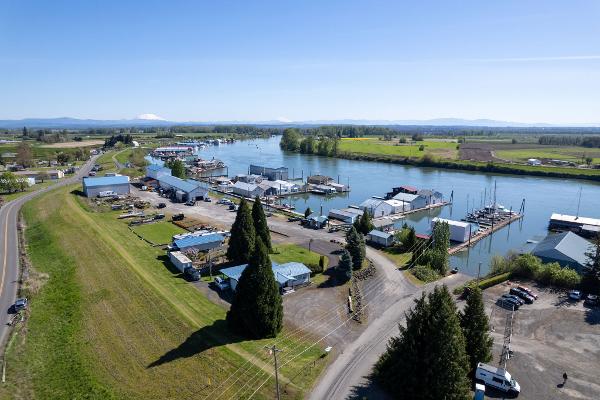 Aerial view of Larson Boathouse, 1985, by a scenic river with surrounding greenery.