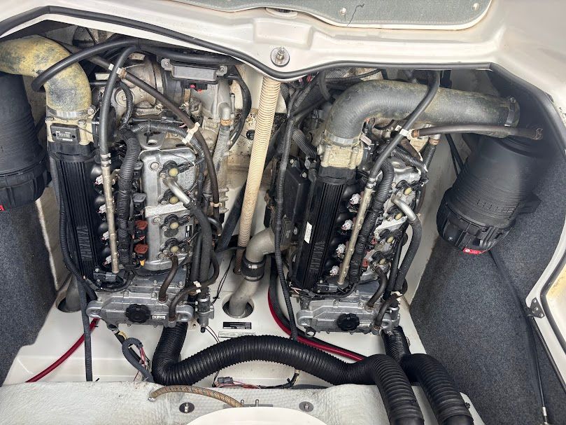 The engine compartment of a 2007 Yamaha AR210 boat shows two engines with hoses and cables.