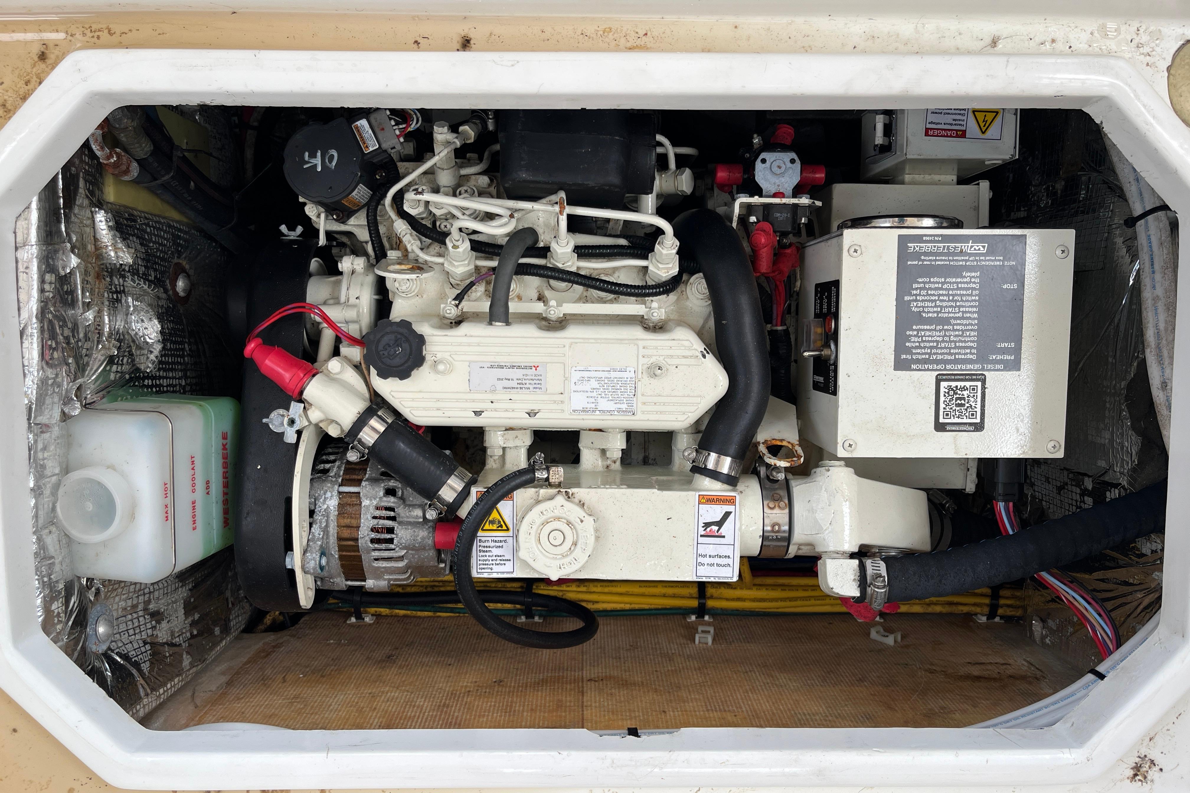 Engine compartment of a 2006 MJM 34z boat, showcasing mechanical components and wiring.