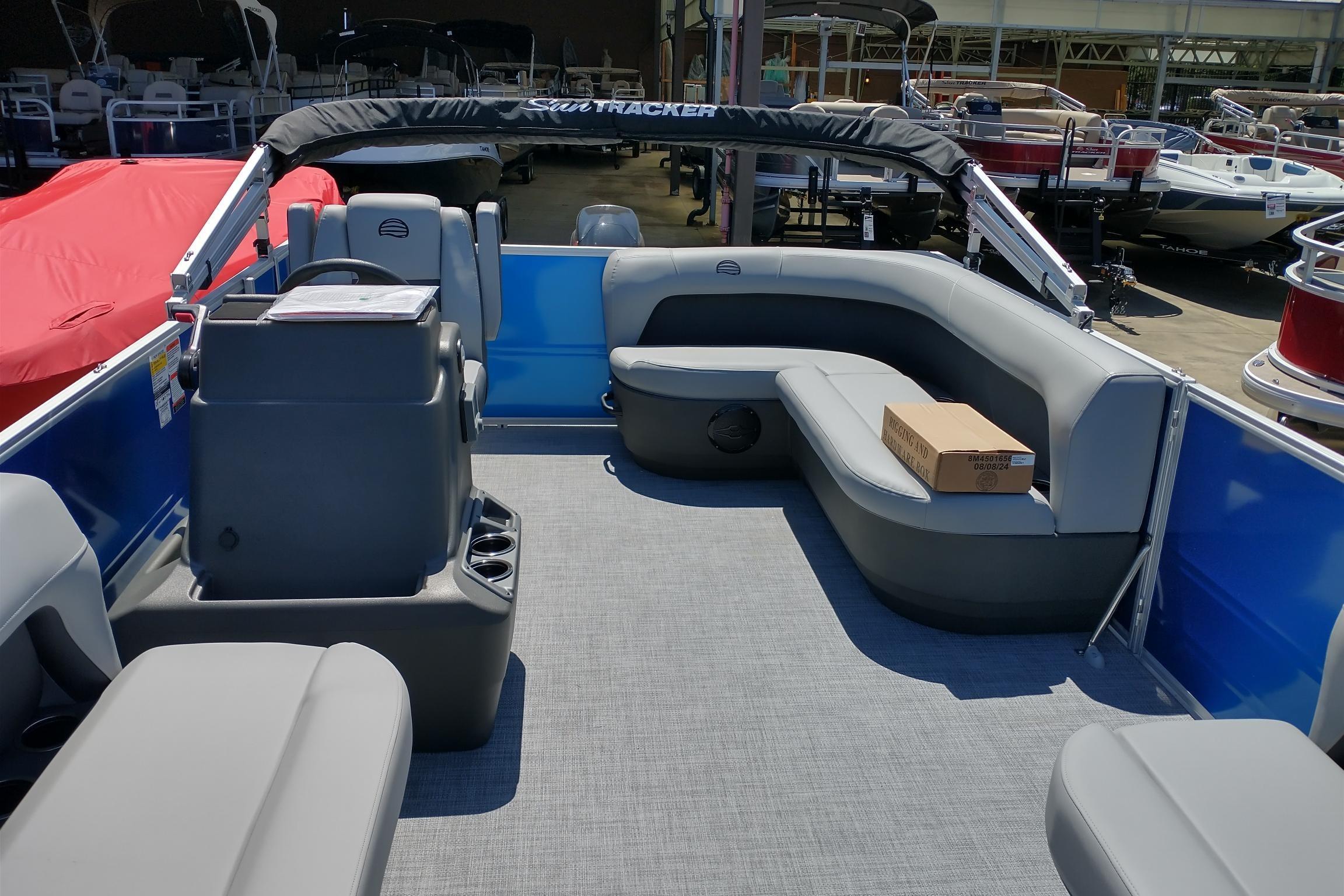 2026 Sun Tracker Party Barge 16 DLX pontoon boat interior with gray seating and helm.
