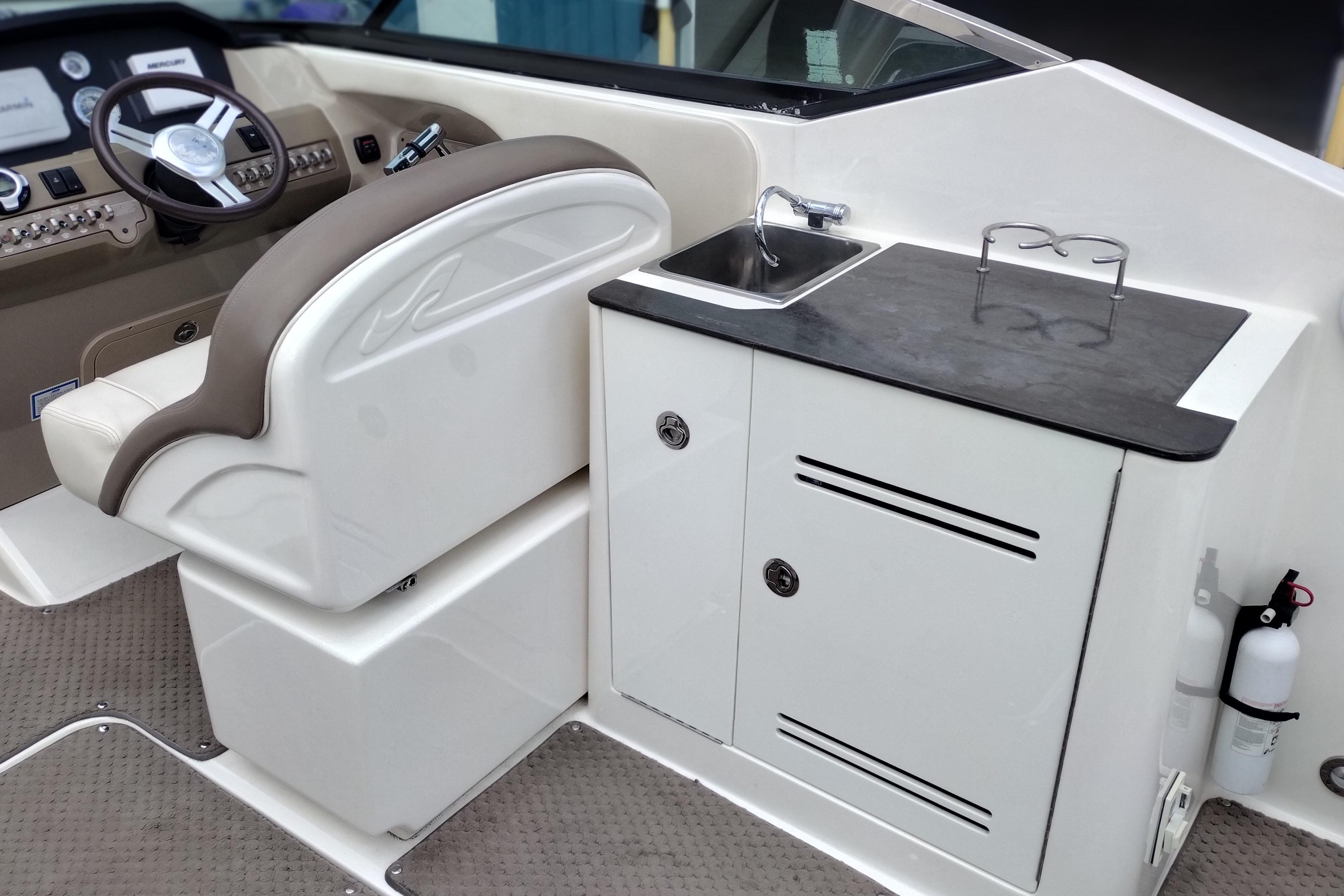 2013 Sea Ray 300 SLX boat interior with helm, sink, and storage cabinet.