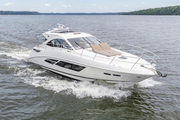 2016 Sea Ray Sundancer 510 cruising on a serene lake with lush green shoreline.