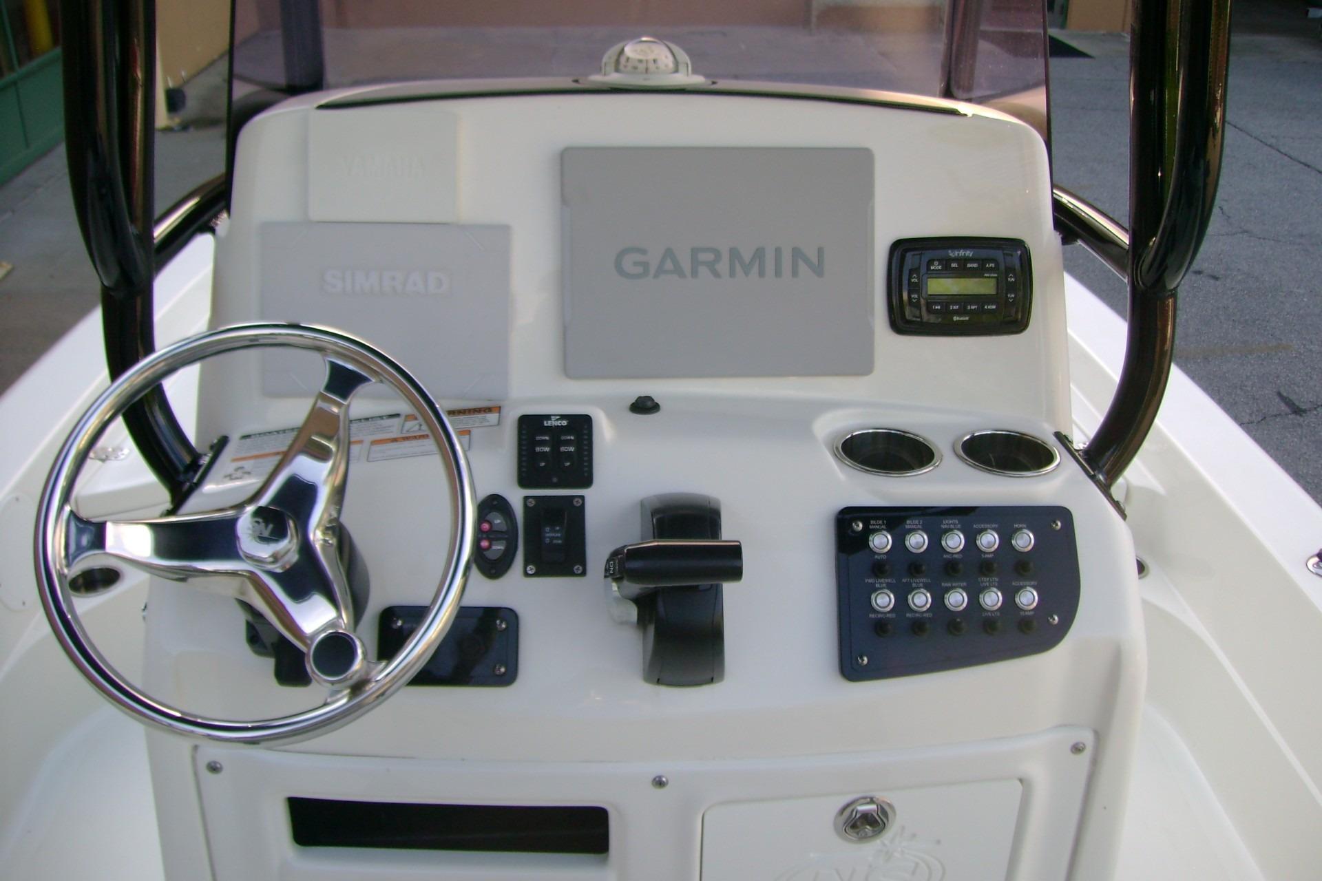 2022 NauticStar 227 XTS boat console with steering wheel, Garmin, and Simrad displays.