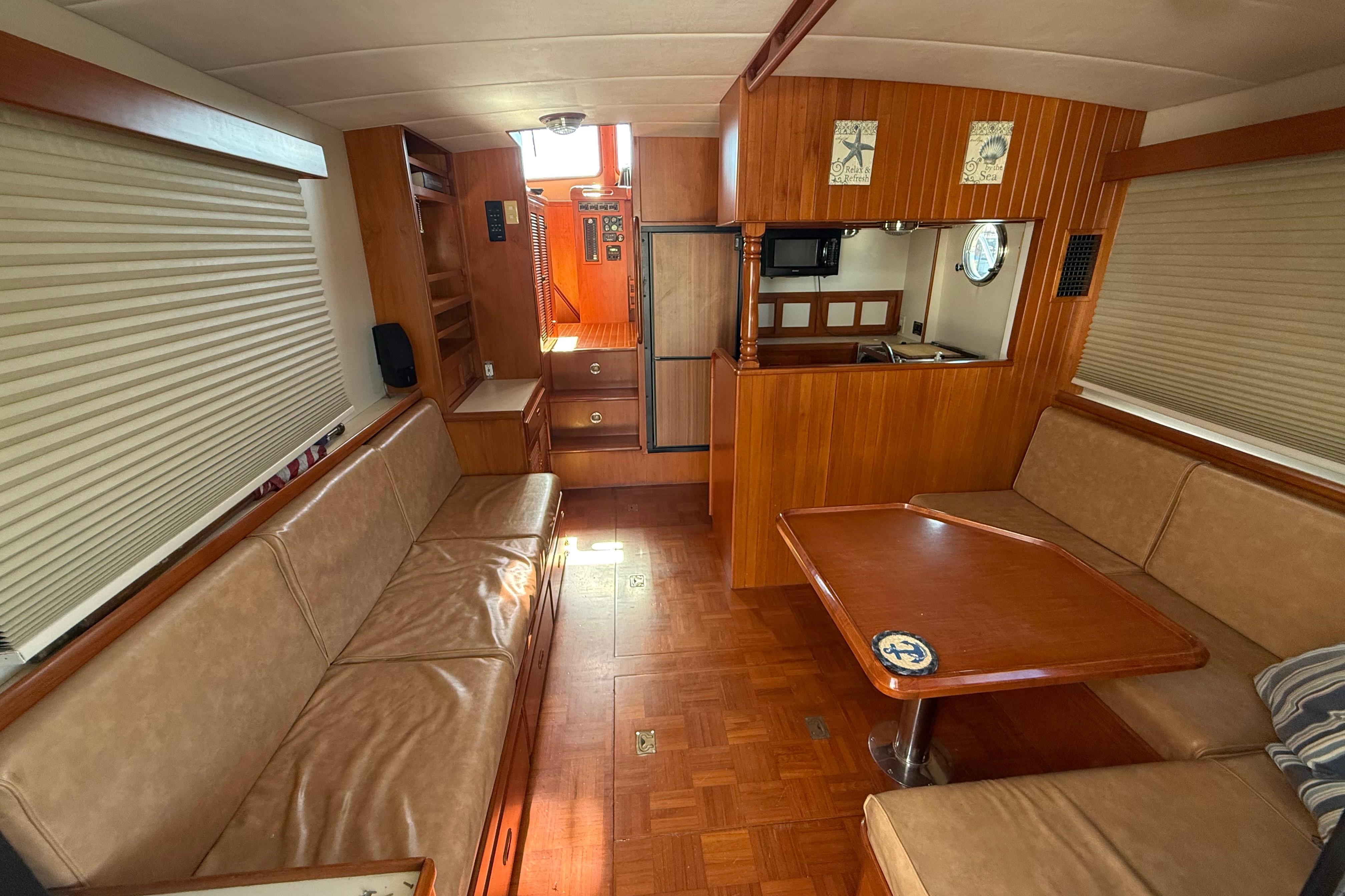 Interior of a 2001 Kadey-Krogen 39 yacht with wood paneling and leather seating.