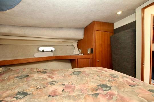 1996 Bayliner 3788 Command Bridge Motoryacht cabin interior with floral bedding and wooden cabinetry.
