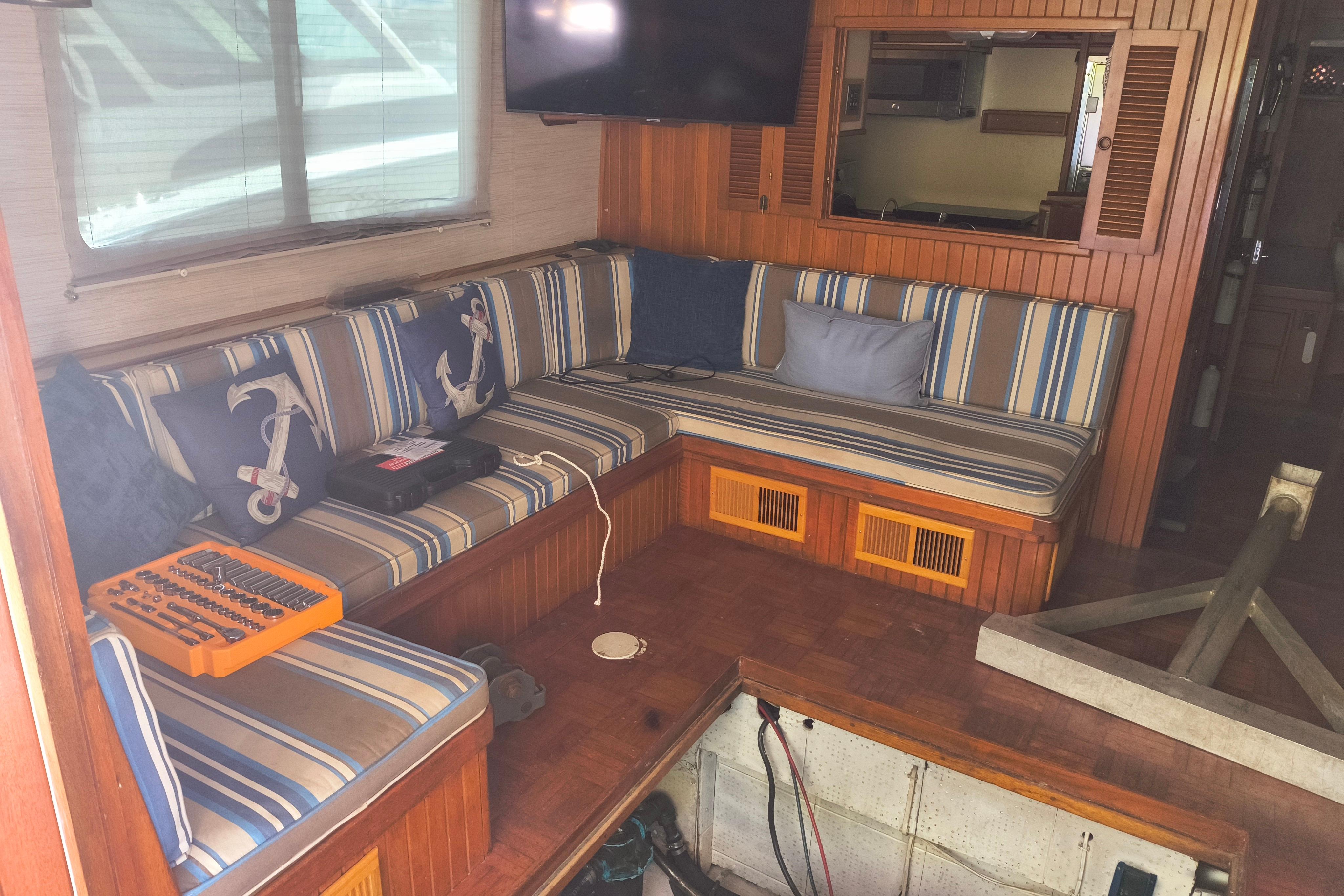 Interior of 1984 Kadey-Krogen Manatee boat with striped seating and nautical-themed cushions.