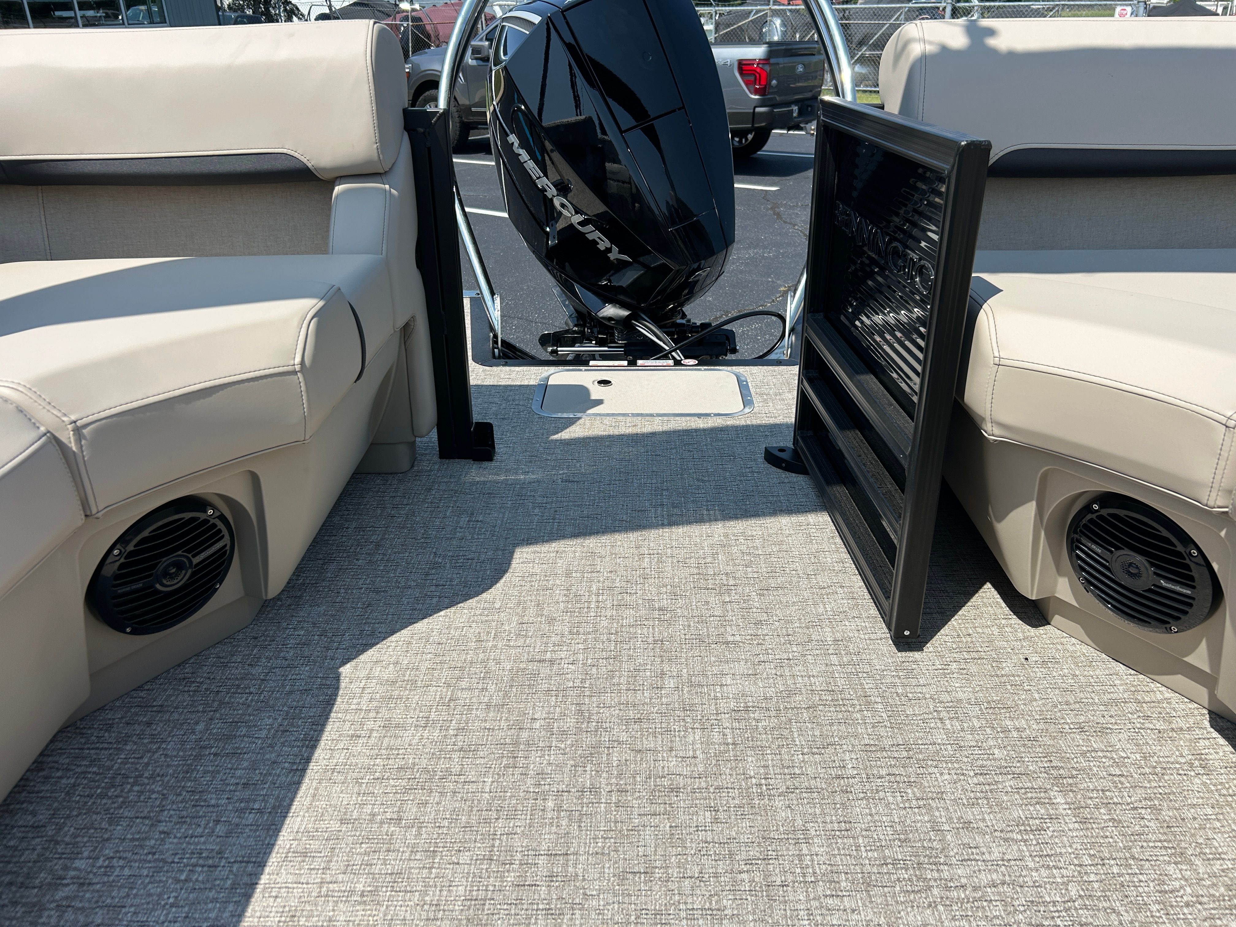 Interior of a Bennington 22 MFB with beige seating and an outboard motor.