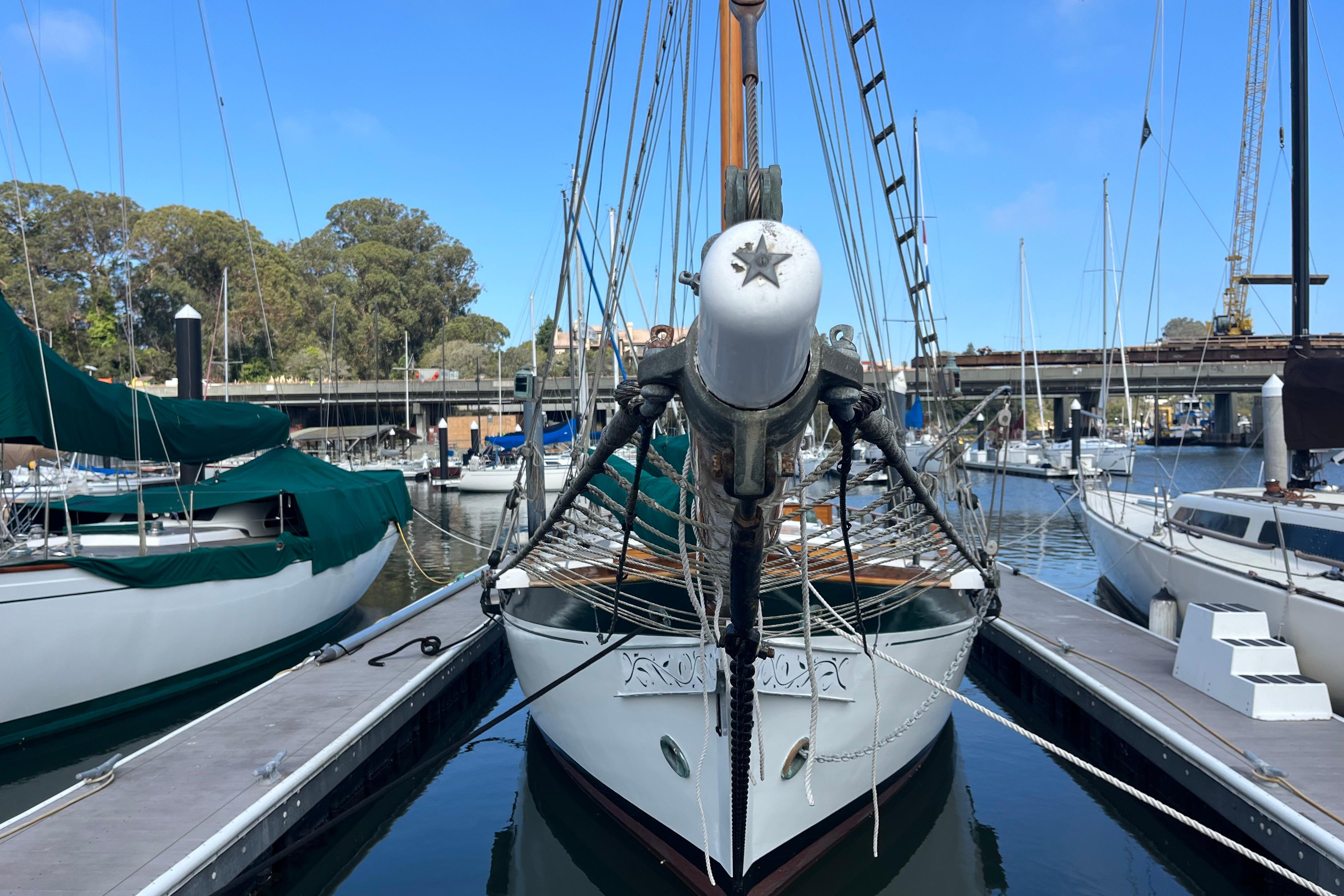 1947 Murray Peterson Schooner docked at a marina, surrounded by other boats.