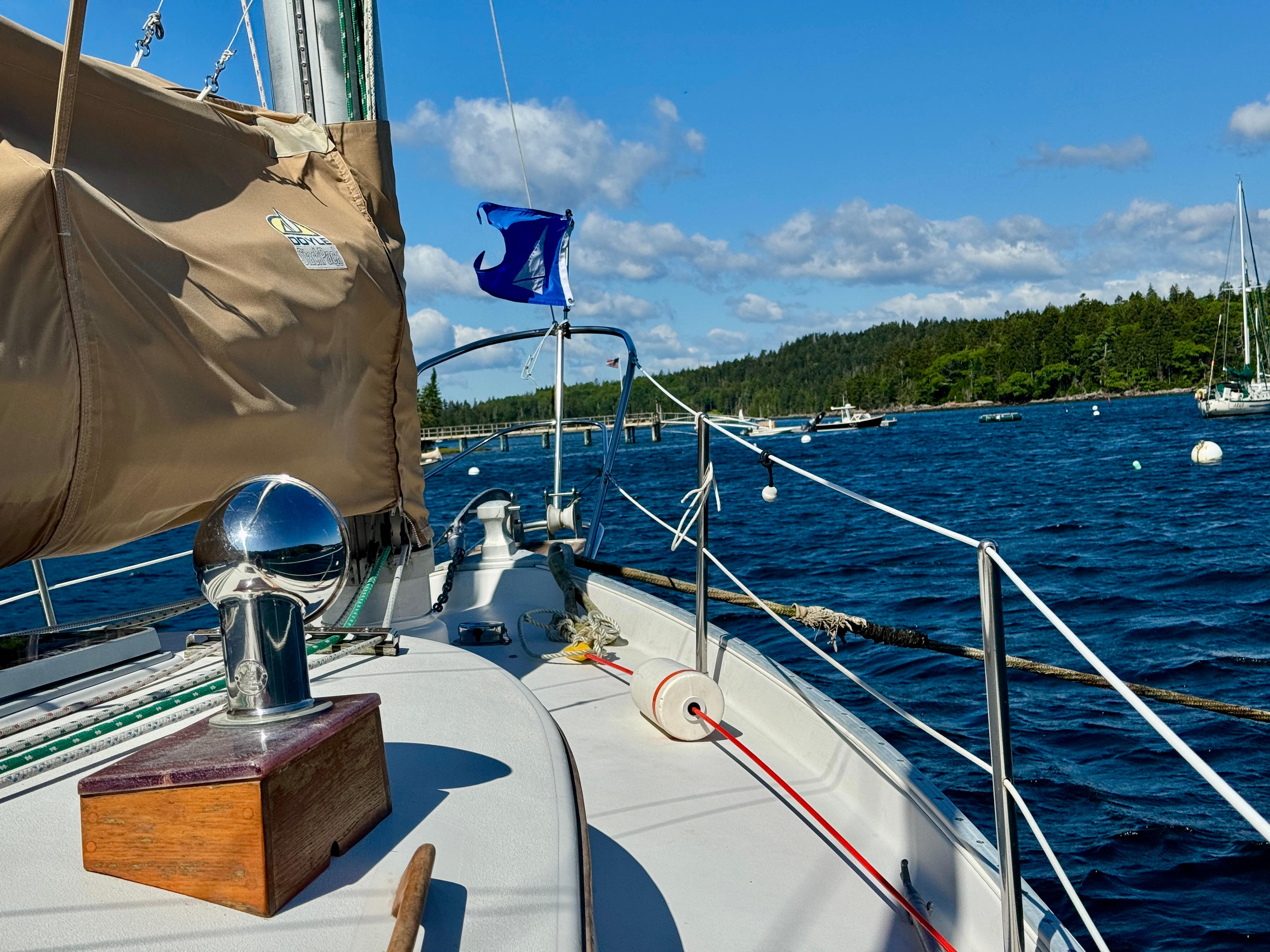 Sailing on a 1989 Nonsuch 30 Ultra yacht in a scenic bay with clear skies.