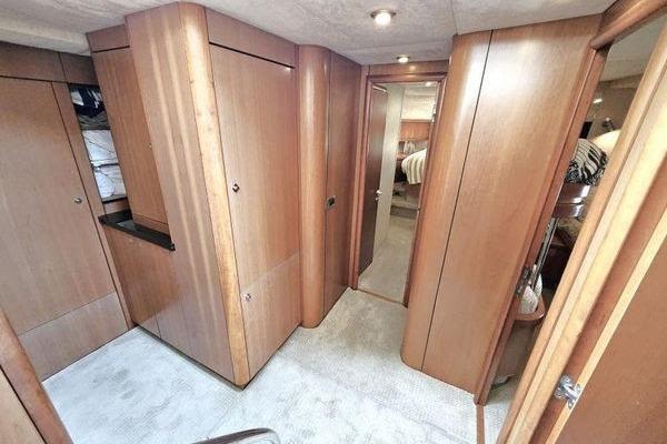 Interior of 2005 Sunseeker Manhattan 66 yacht, featuring wooden cabinetry and carpeted flooring.