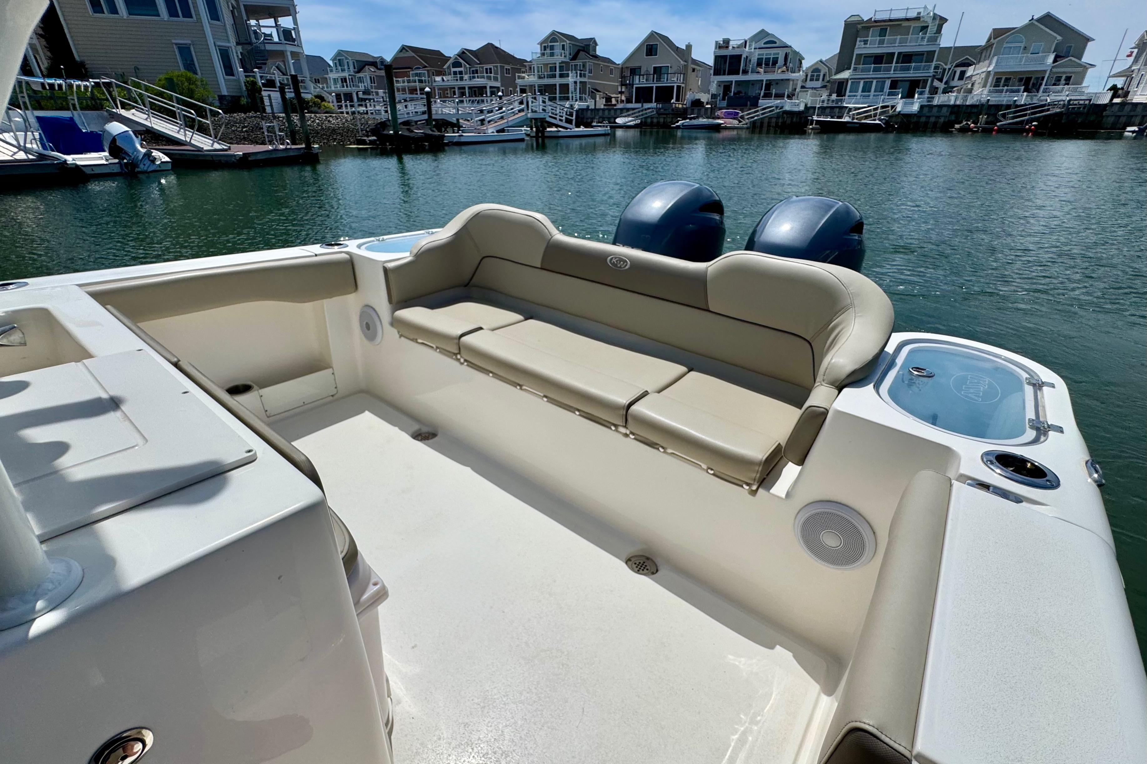 2022 Key West 263 FS boat interior with seating, docked near waterfront homes.