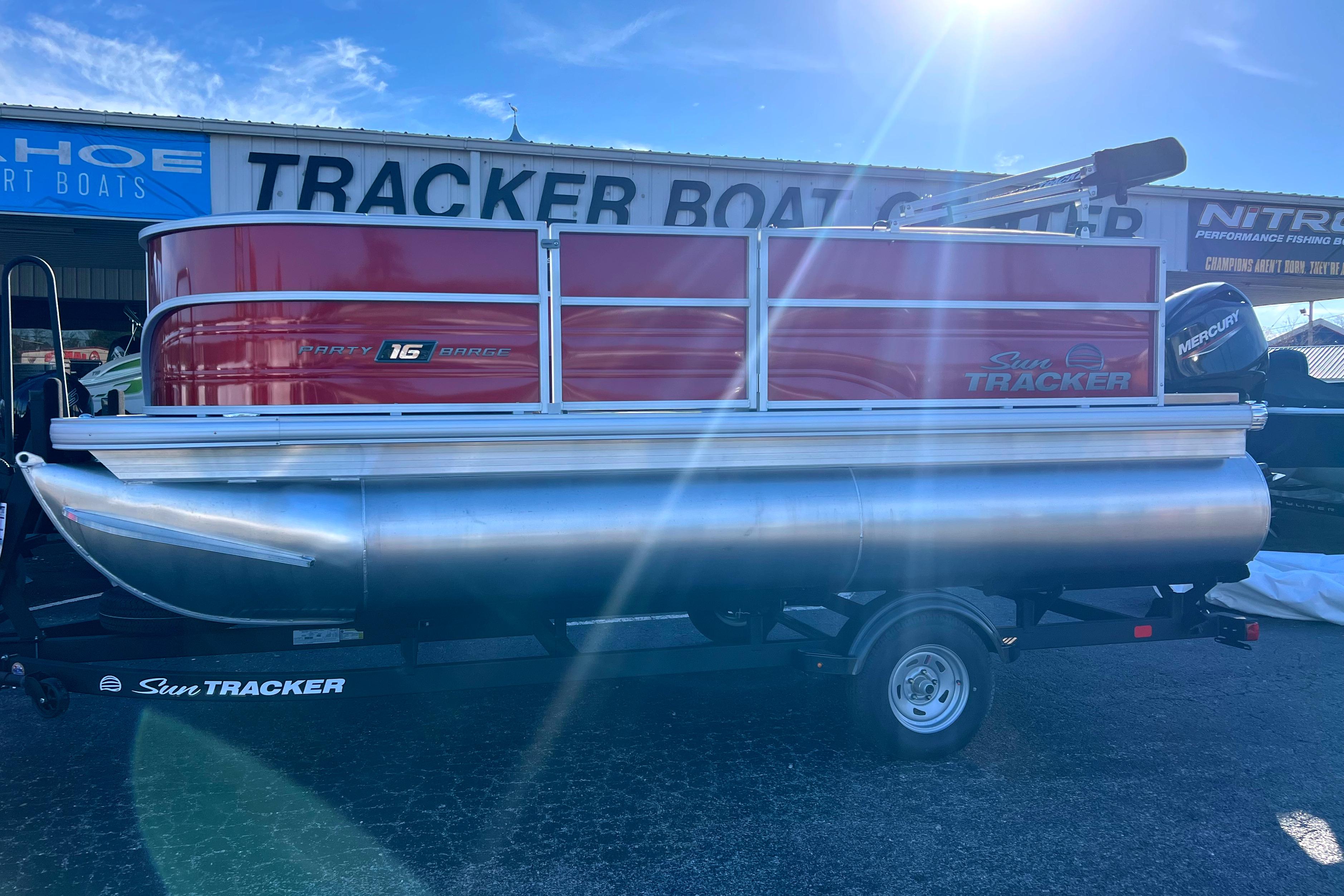 2026 Sun Tracker Party Barge 16 DLX pontoon boat on trailer in sunlight.