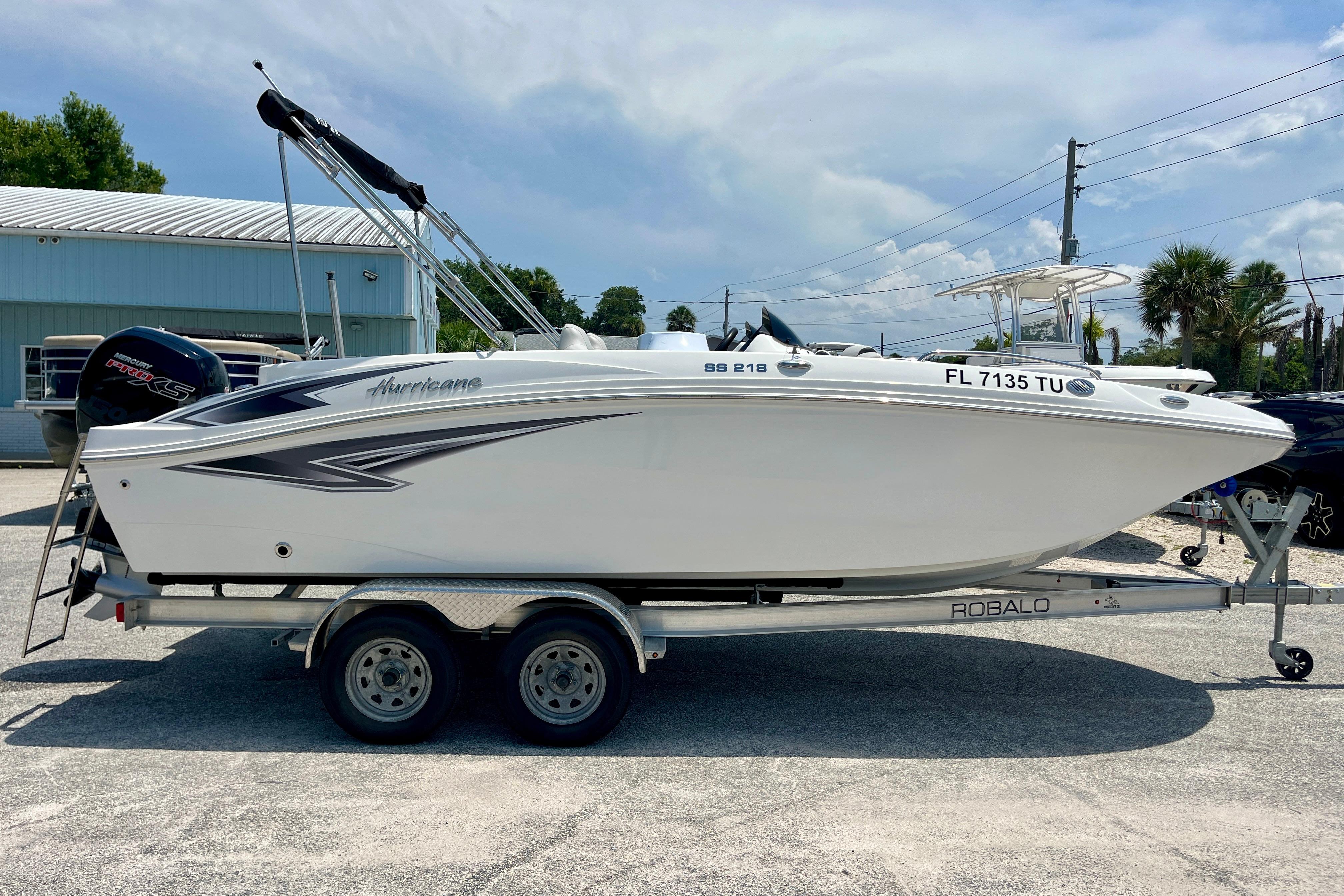 2024 Hurricane Sundeck Sport 218 OB boat on trailer, parked outdoors.