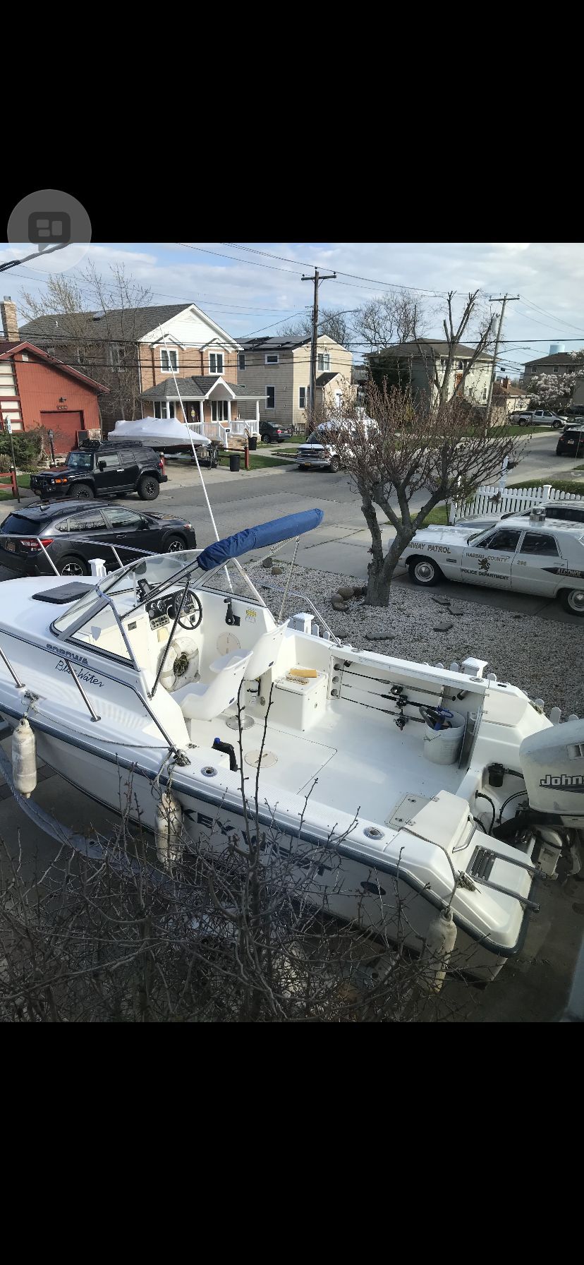 A 2000 Key West 20 WA boat on a trailer in a residential area.