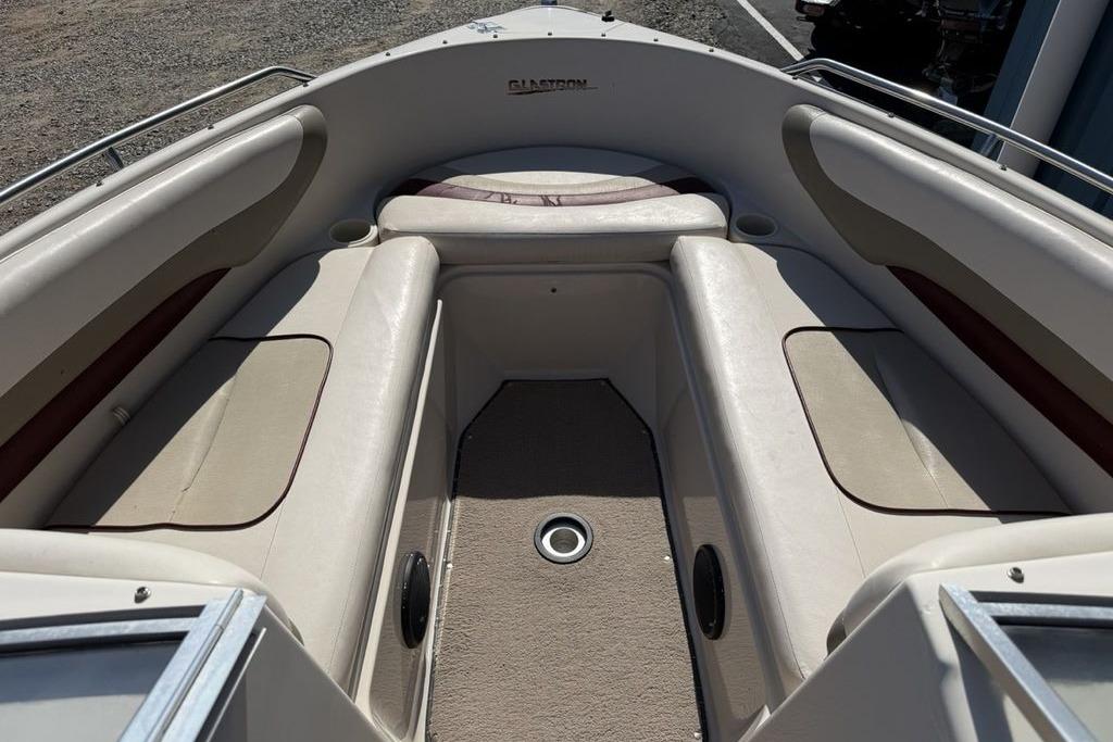 1999 Glastron GT 225 boat interior with beige seating and carpeted floor.