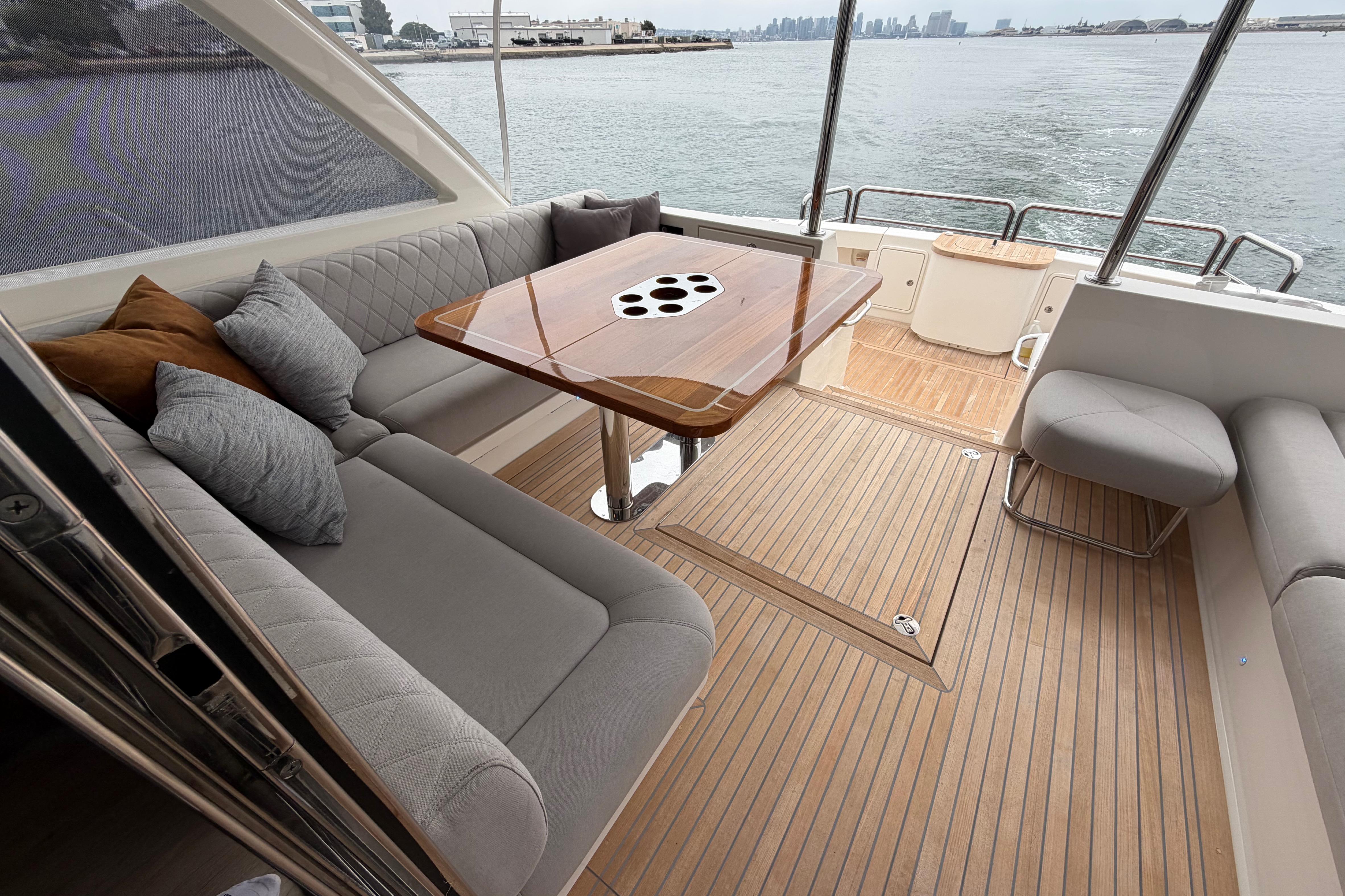 Luxurious 2023 Riviera 645 SUV yacht interior with elegant seating and wooden table.